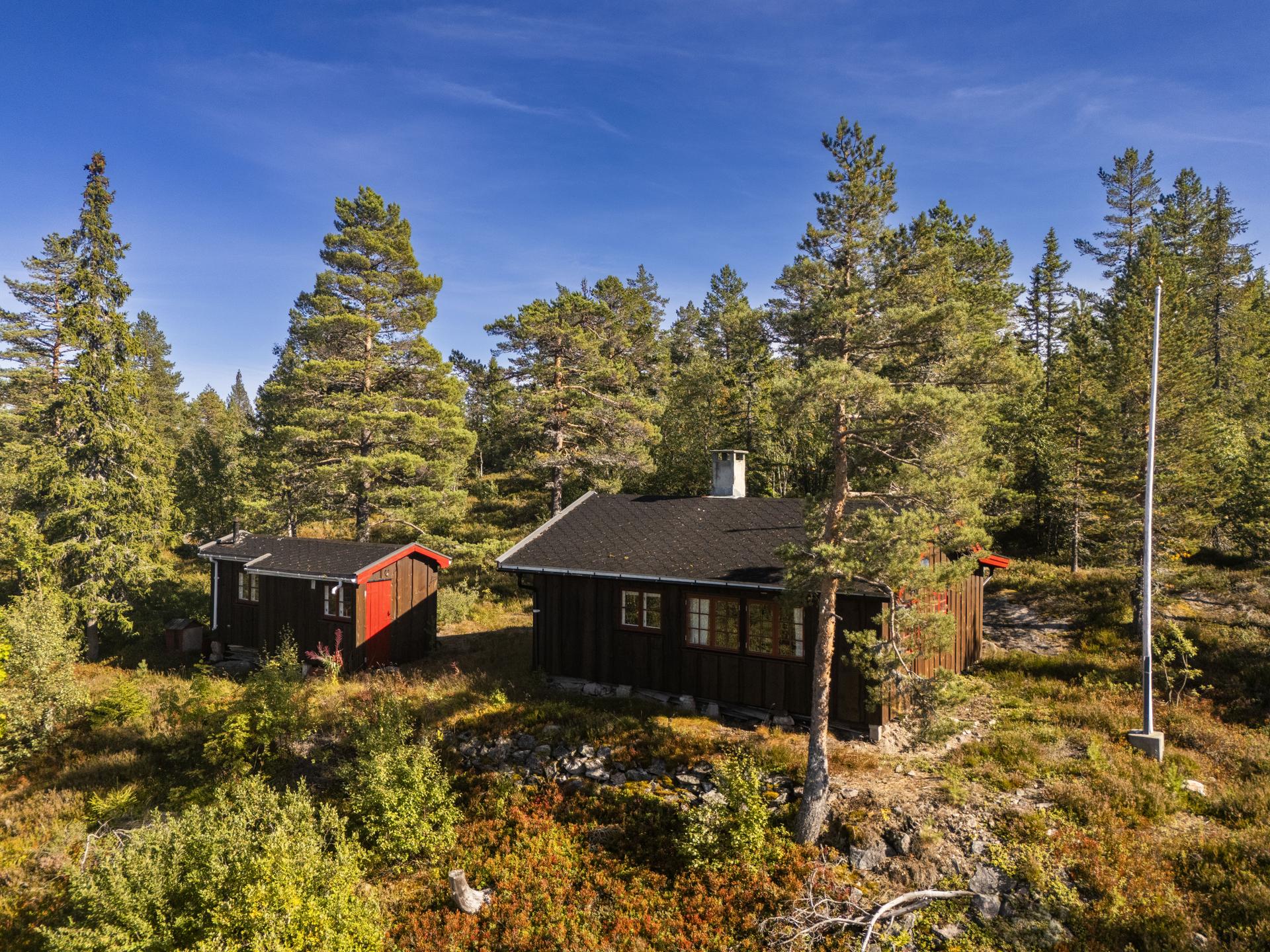 Fritidsbolig oppført i 1962, usjenert beliggende i skog- og fjellterreng med tilhørende utebod.. Bilde nummer 2 av 3