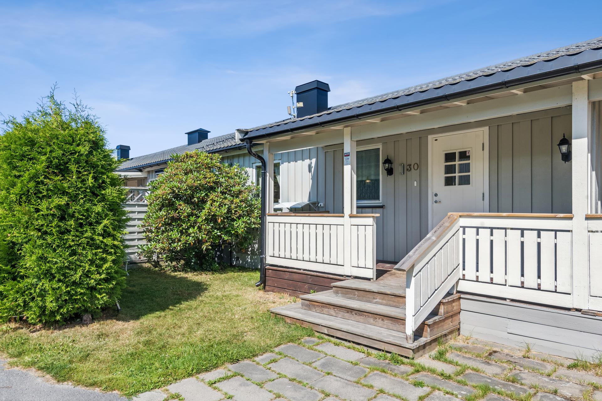 Inngangspartiet har belegningsstein og en takoverbygget terrasse.. Bilde nummer 2 av 3