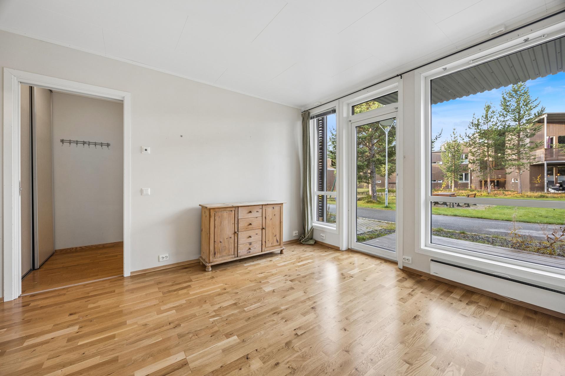 Stuen har parkett på gulvet og gode vindusflater som slipper inn dagslys.. Bilde nummer 3 av 3