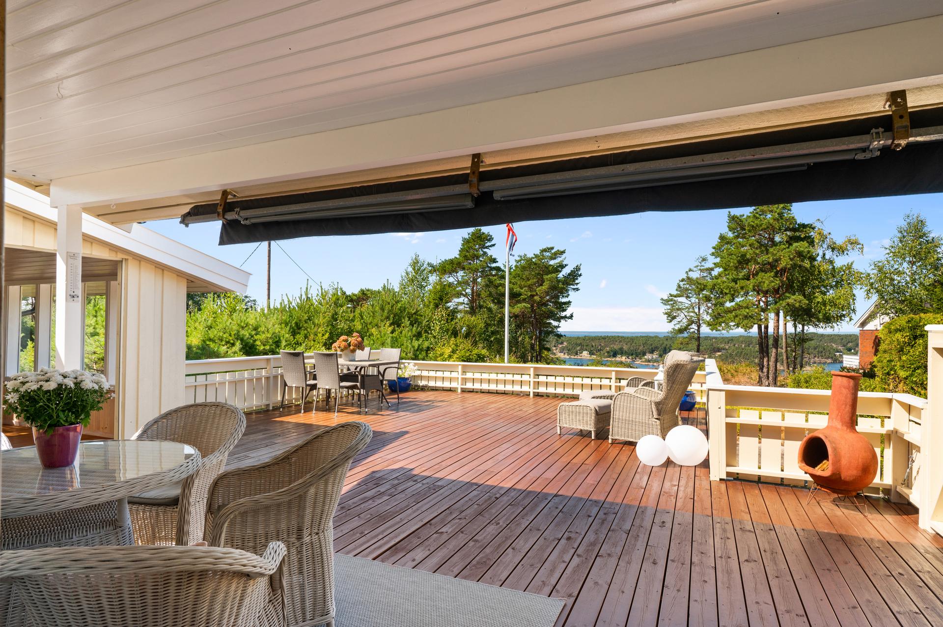 Den svært romslige verandaen har rikelig med plass for både spisebord og loungegruppe.. Bilde nummer 3 av 3