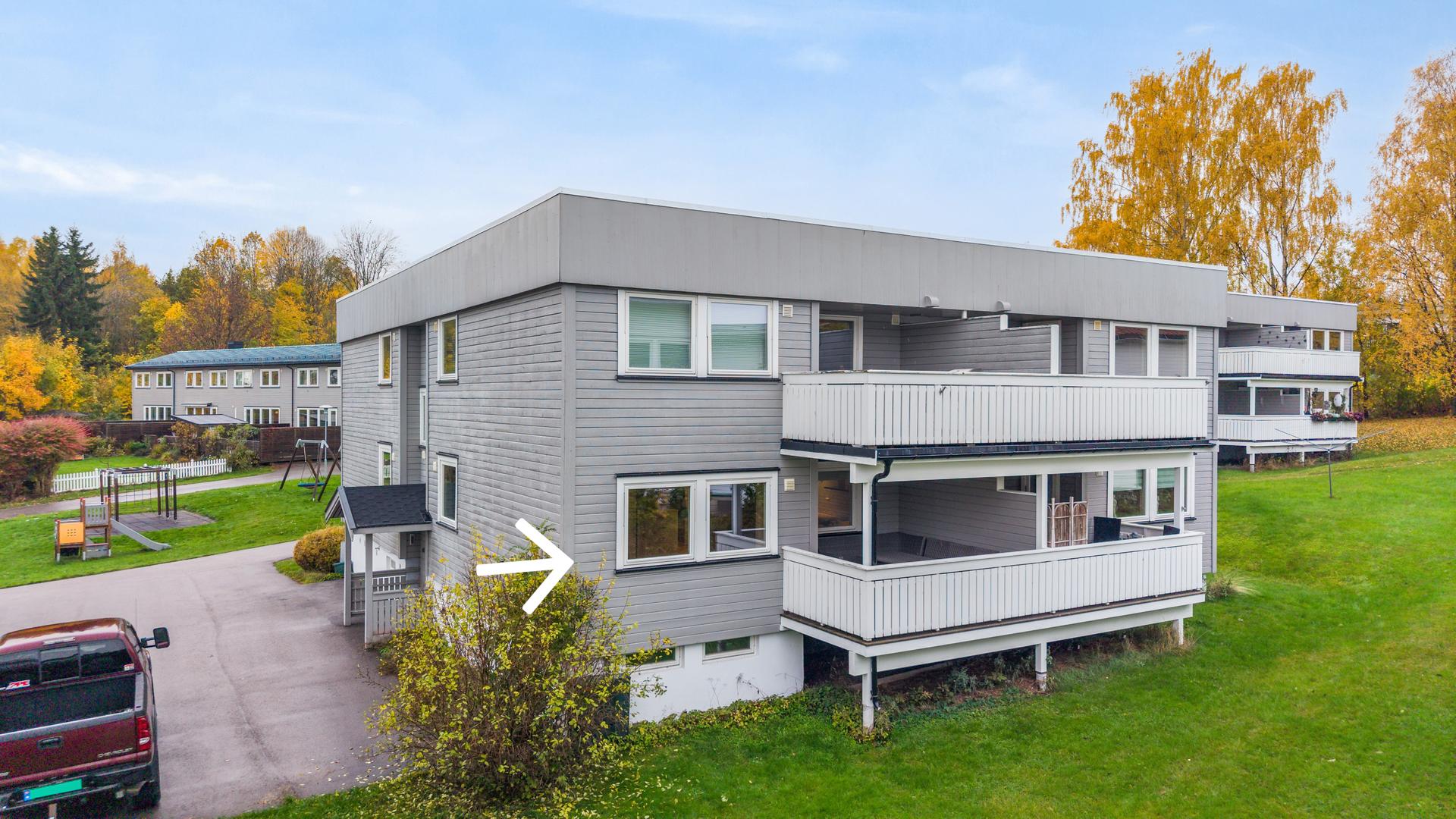 Fasaden mot grøntarealet viser leilighetens overbygde veranda i første etasje.. Bilde nummer 3 av 3
