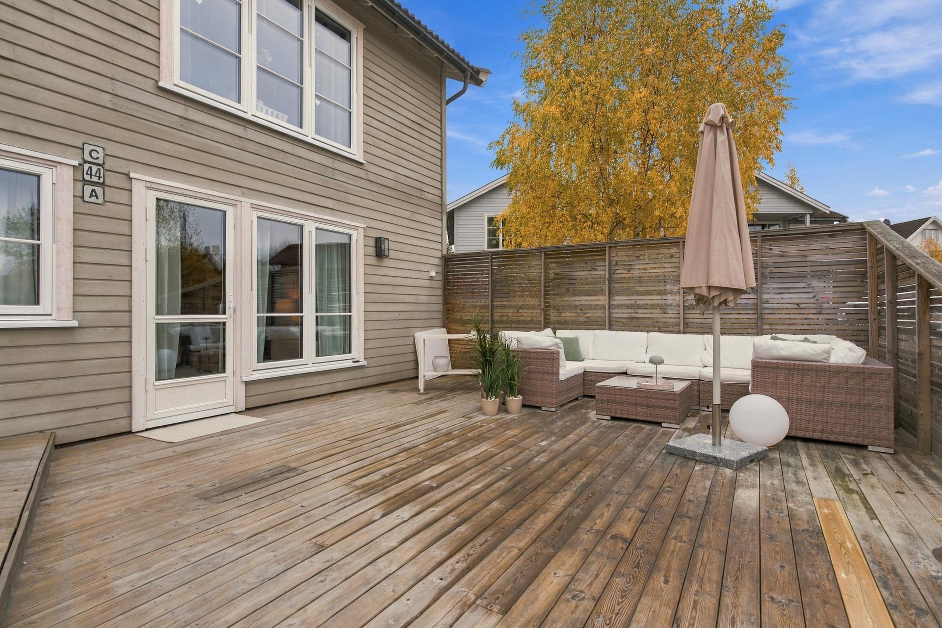 Terrasse i tre over to nivåer med utgang fra stuen.. Bilde nummer 2 av 3