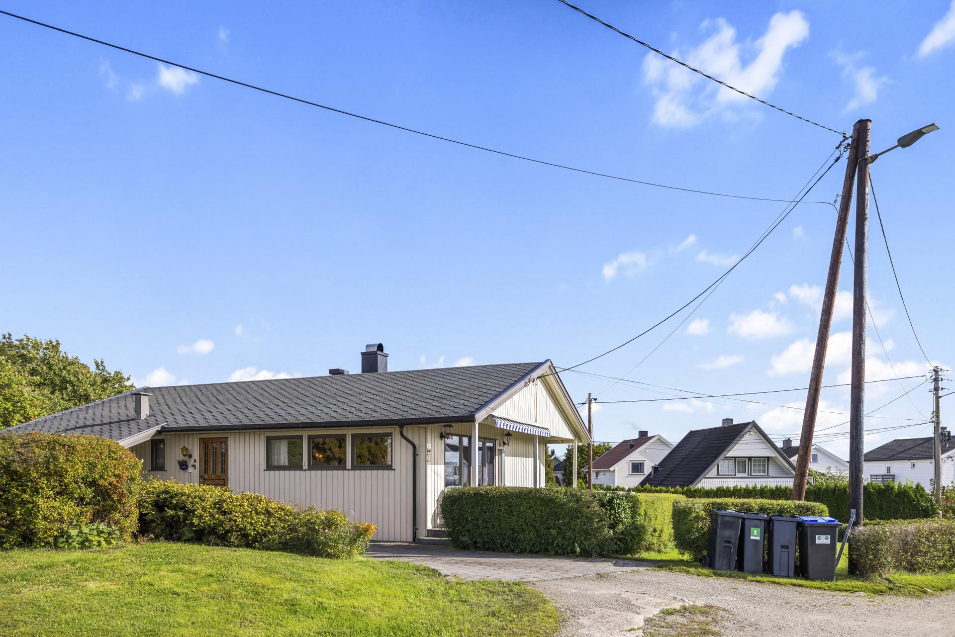 Klassisk enebolig over ett plan med overbygd carport, romslig terrasse og pent opparbeidet tomt.. Bilde nummer 3 av 3