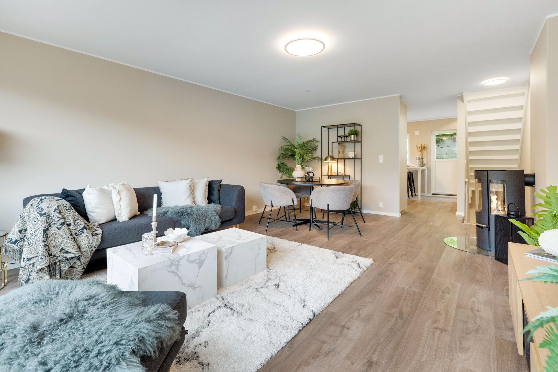 Den åpne løsningen i første etasje gir en sosial sone med plass til både sofagruppe og spisebord.. Bilde nummer 1 av 3