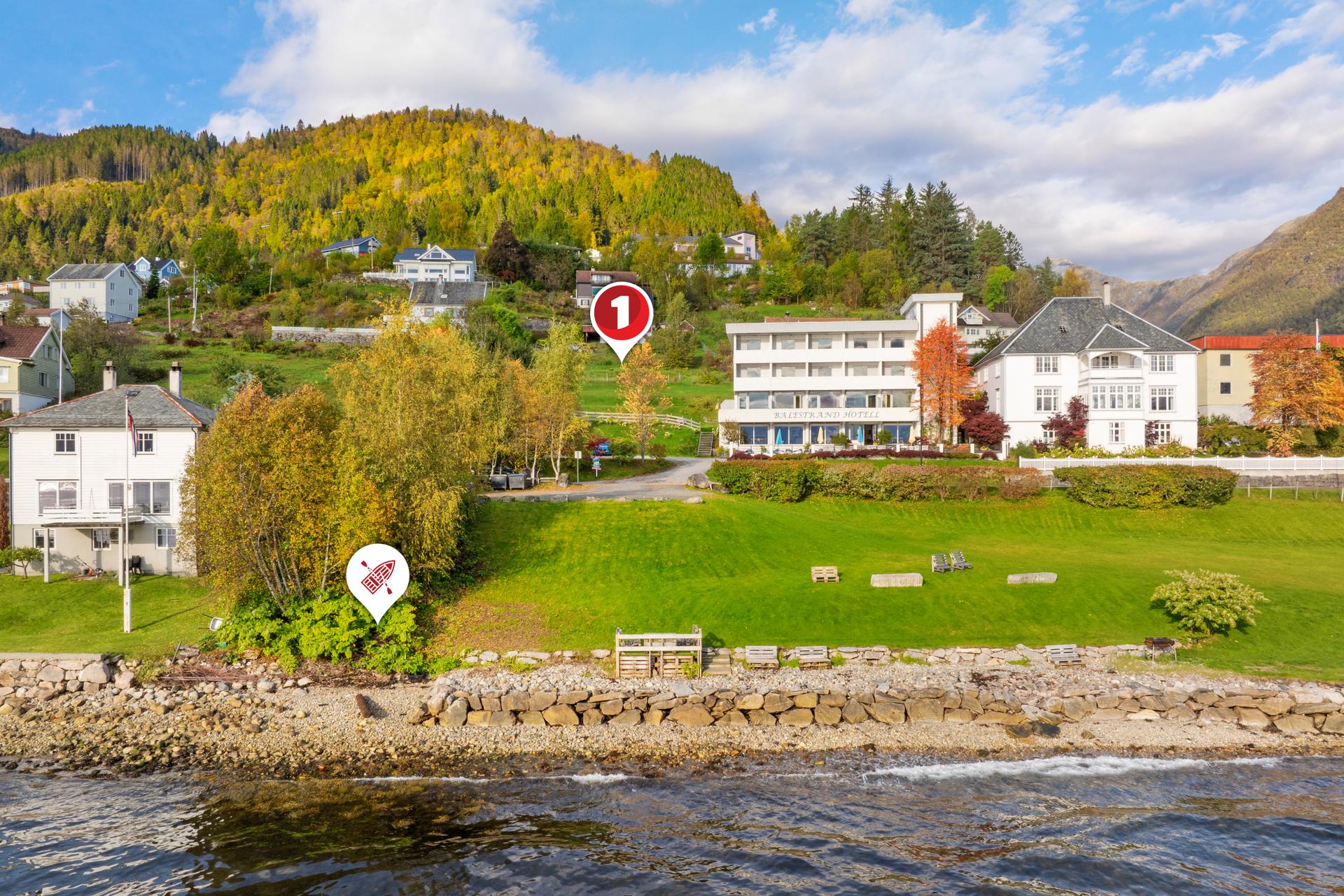 Bustadtomta har attraktiv og barnevennleg plassering i Lærargata, med tilhøyrande sjøtomt nede ved fjorden.. Bilde nummer 2 av 3