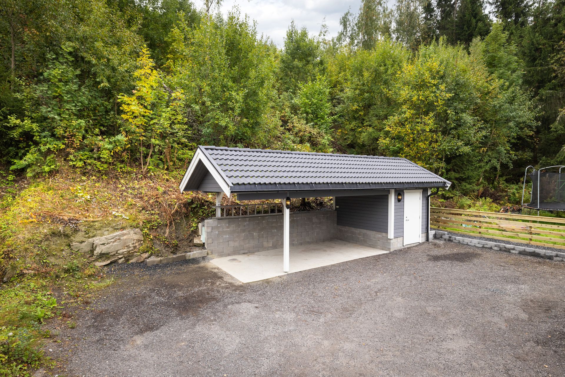 Boligen har gode parkeringsmuligheter i carport fra 2019 og gruset gårdsplass.. Bilde nummer 3 av 3