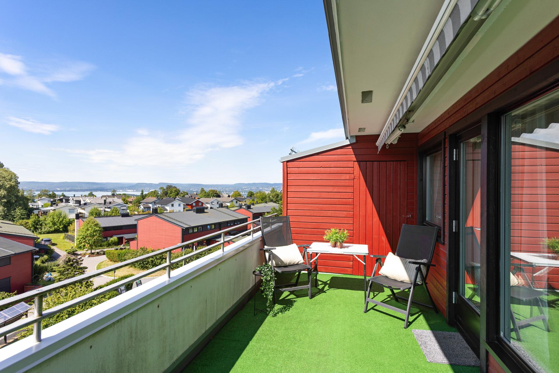 Leiligheten har en stor, sørvestvendt terrasse med utsikt over nærområdet og glimt av sjøen.. Bilde nummer 2 av 3