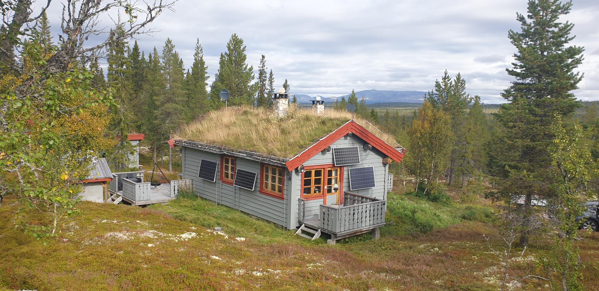 Hytta glir fint inn i terrenget, her vist i sommerdrakt. Selgers foto. . Bilde nummer 2 av 3