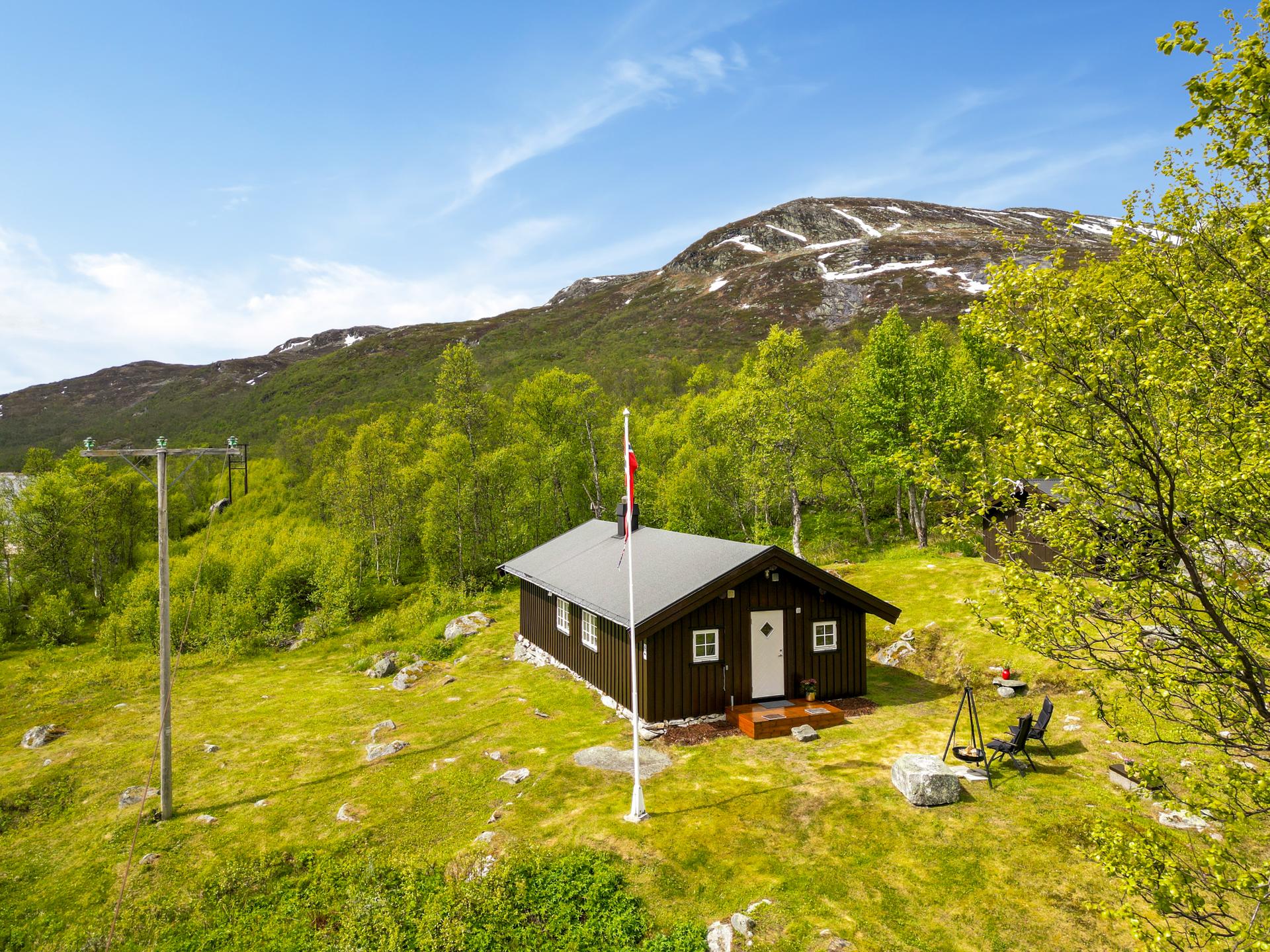 Hytta ligger usjenert til, med fjellandskapet som omkranser eiendommen.. Bilde nummer 3 av 3