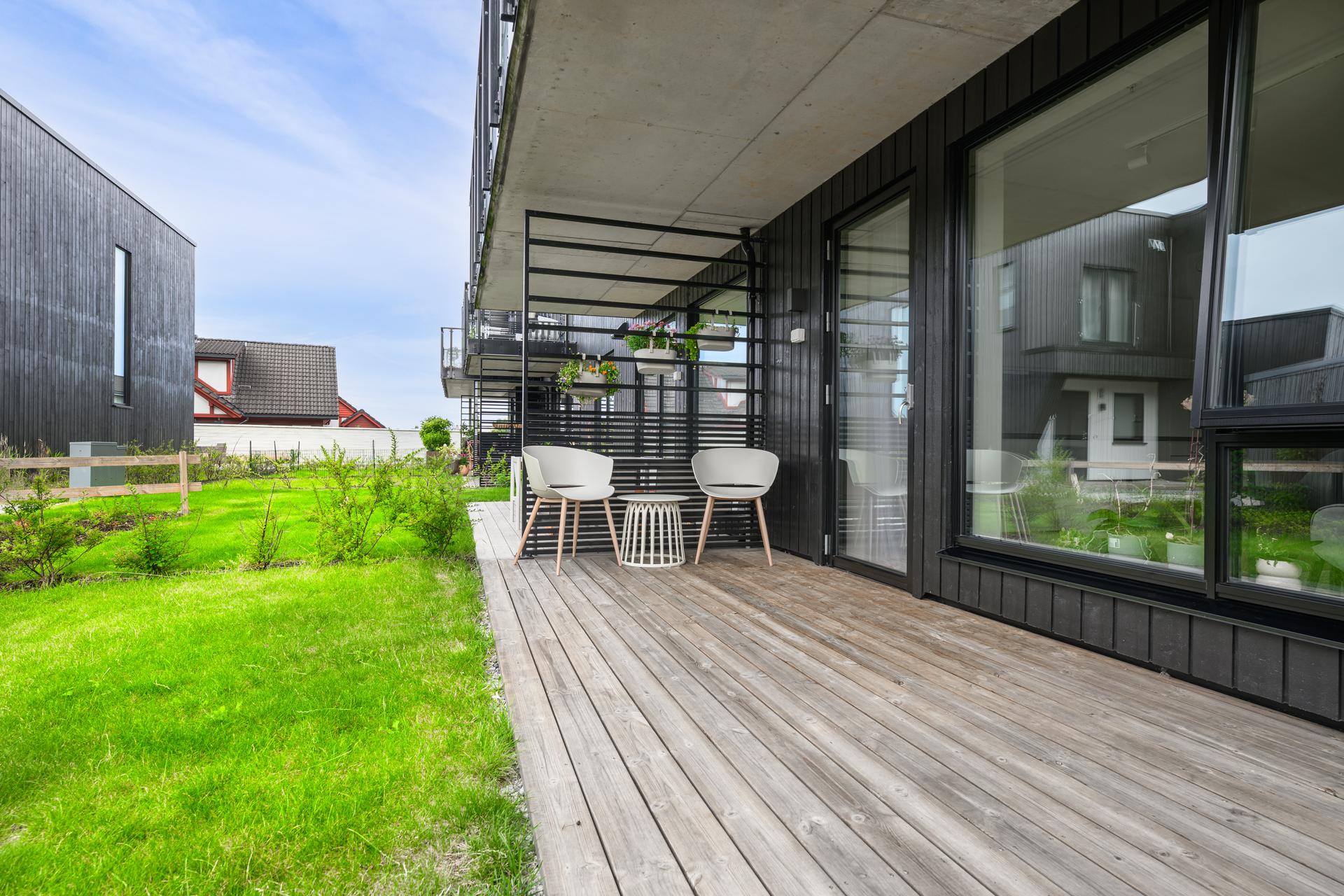 Direkte utgang til en skjermet terrasse med plass for utemøbler.. Bilde nummer 1 av 3