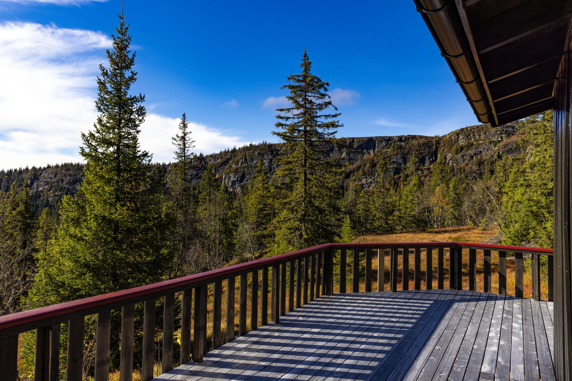 Hytta har en romslig veranda med flott utsyn over omkringliggende fjellområder.. Bilde nummer 3 av 3