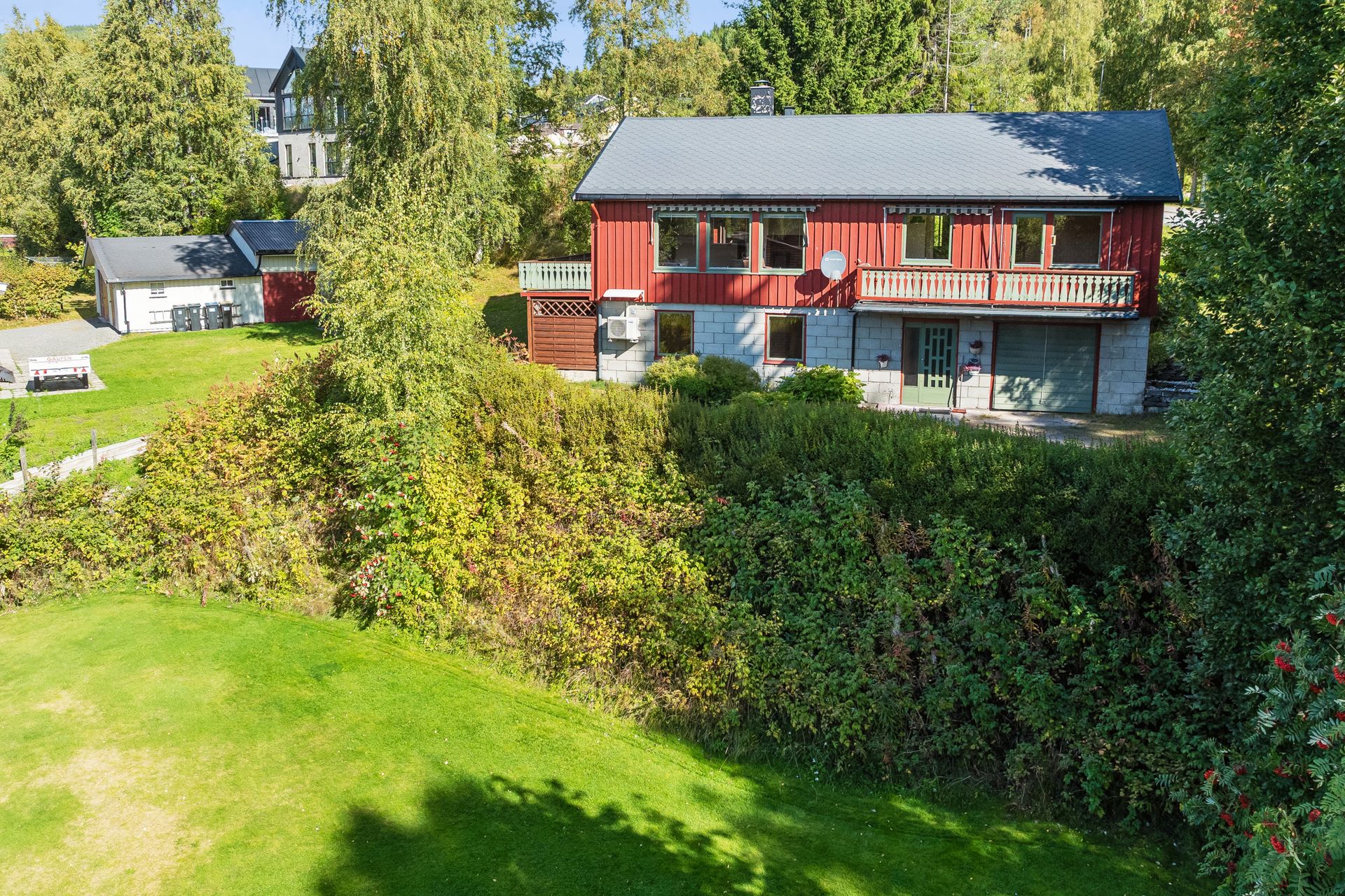 Eiendommen har en opparbeidet tomt med plen, beplantning og frittstående bod.. Bilde nummer 3 av 3