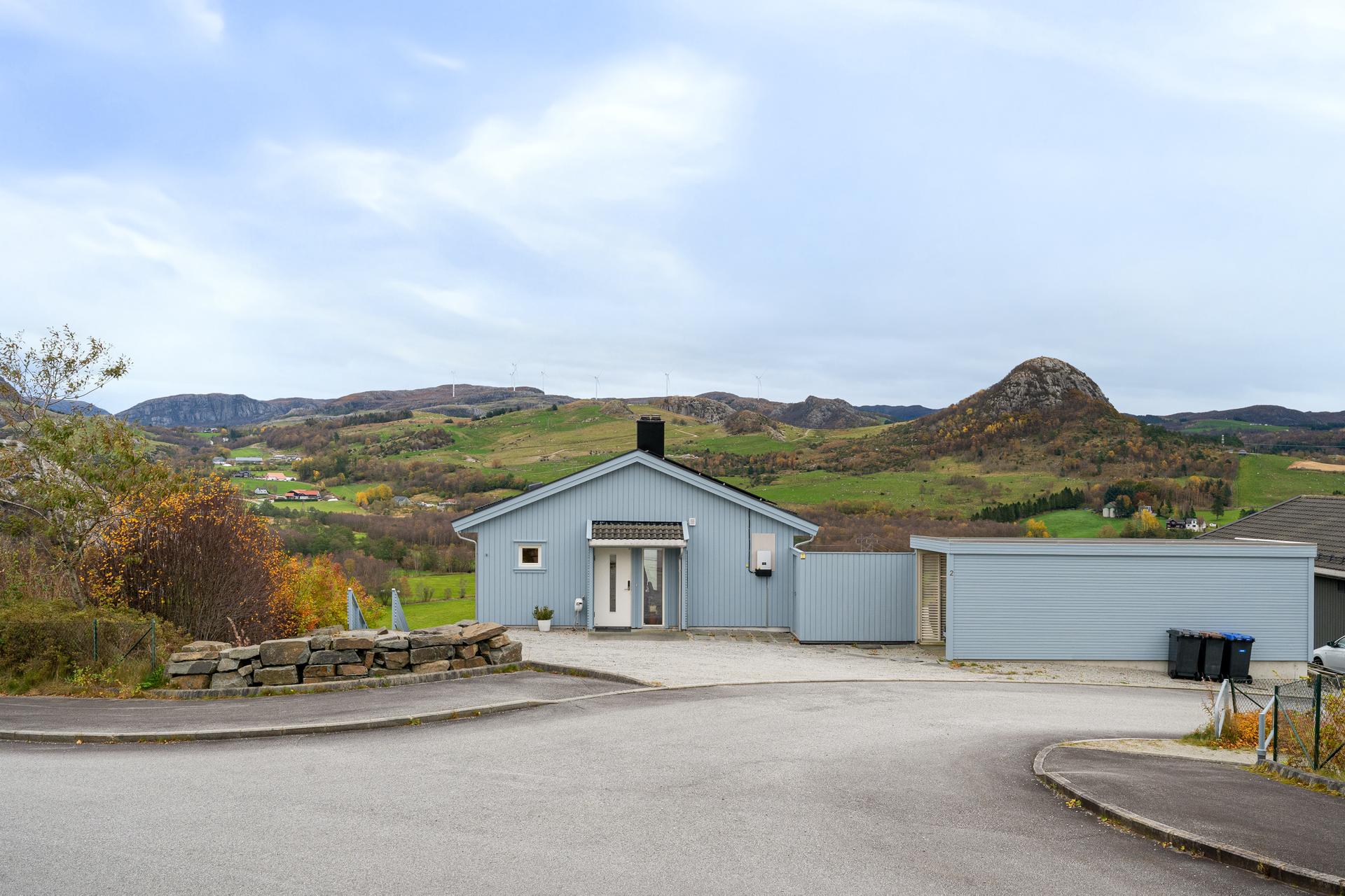 Eneboligen ligger landlig til i et nyere byggefelt  på Sviland, med fantastisk, vidstrakt utsikt til fjell og hei - Carport med elbillader, i tillegg meget godt gårdsrom med plass til flere biler. Bilde nummer 3 av 3