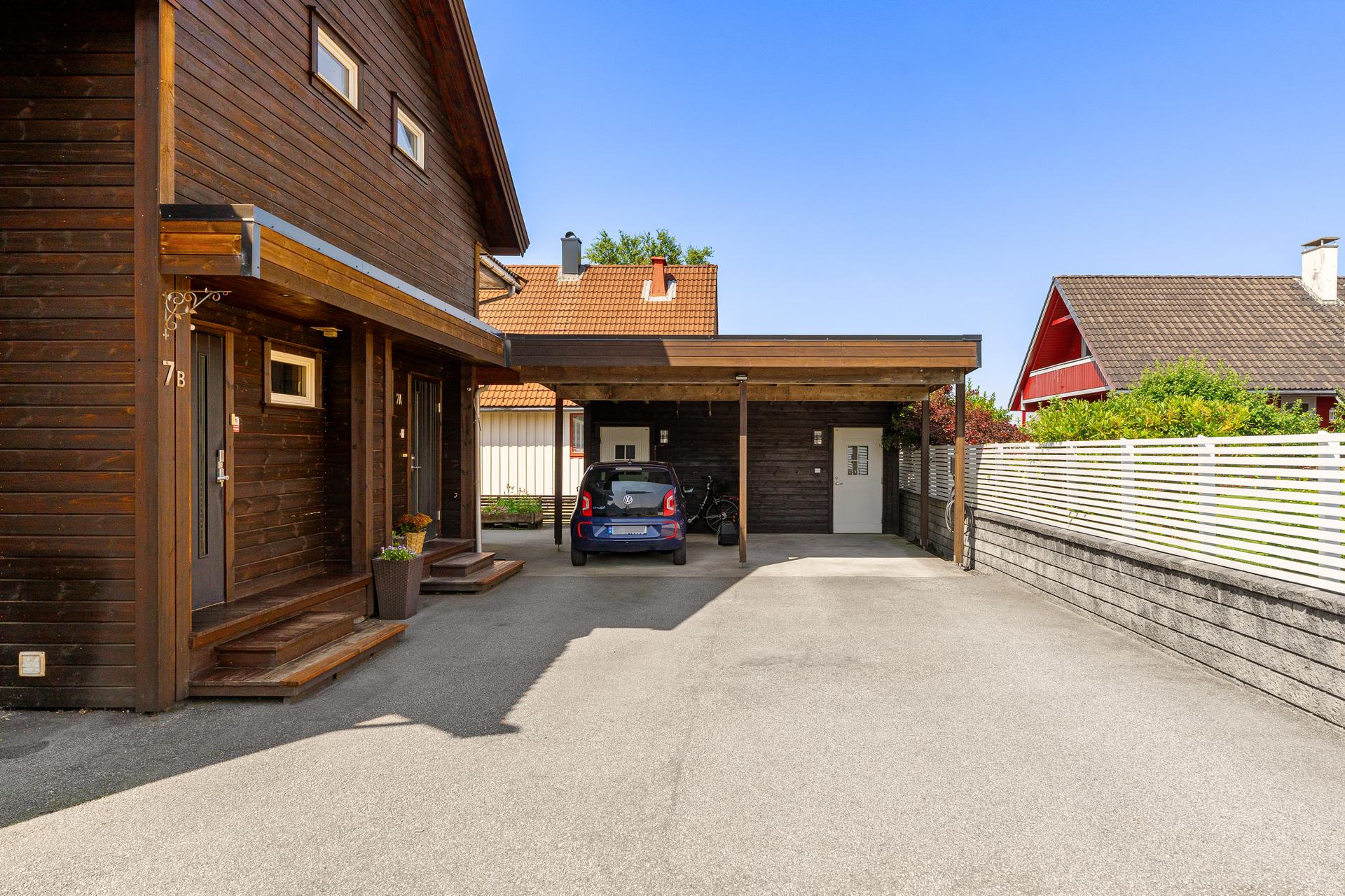 Eiendommen inkluderer en carport med plass til én bil, samt asfaltert gårdsplass med ekstra parkeringsmuligheter. Det er installert elbillader og overspenningsvern. Bilde nummer 3 av 3