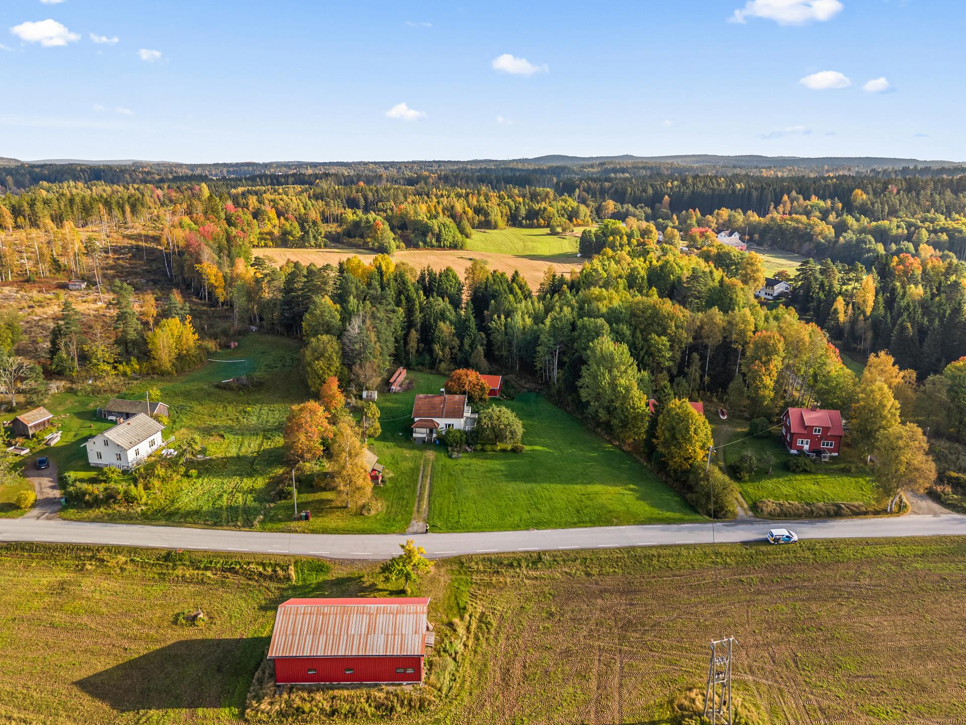 Eiendommen ligger i et åpent landskap med skog og dyrket mark som nærmeste nabo. Foto: Fotoetcetera.. Bilde nummer 1 av 3