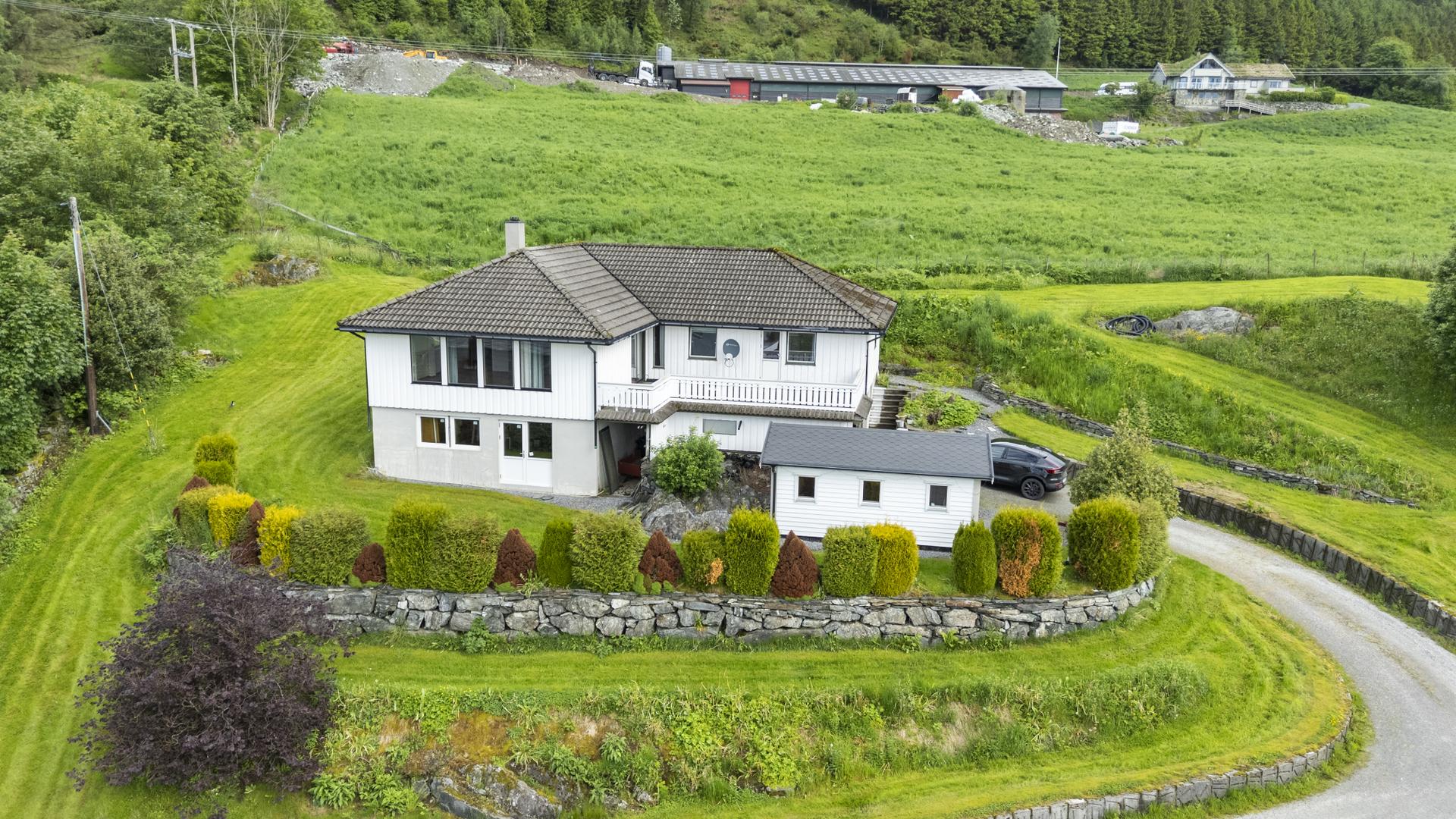 Eigedommen ligg fritt og fint til på eit lite høgdedrag . Bilde nummer 3 av 3