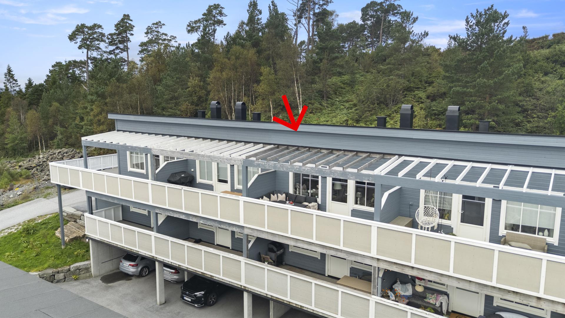 Bustaden ligg fint plassert i rekka, med terrasser vendt mot sør.. Bilde nummer 2 av 3
