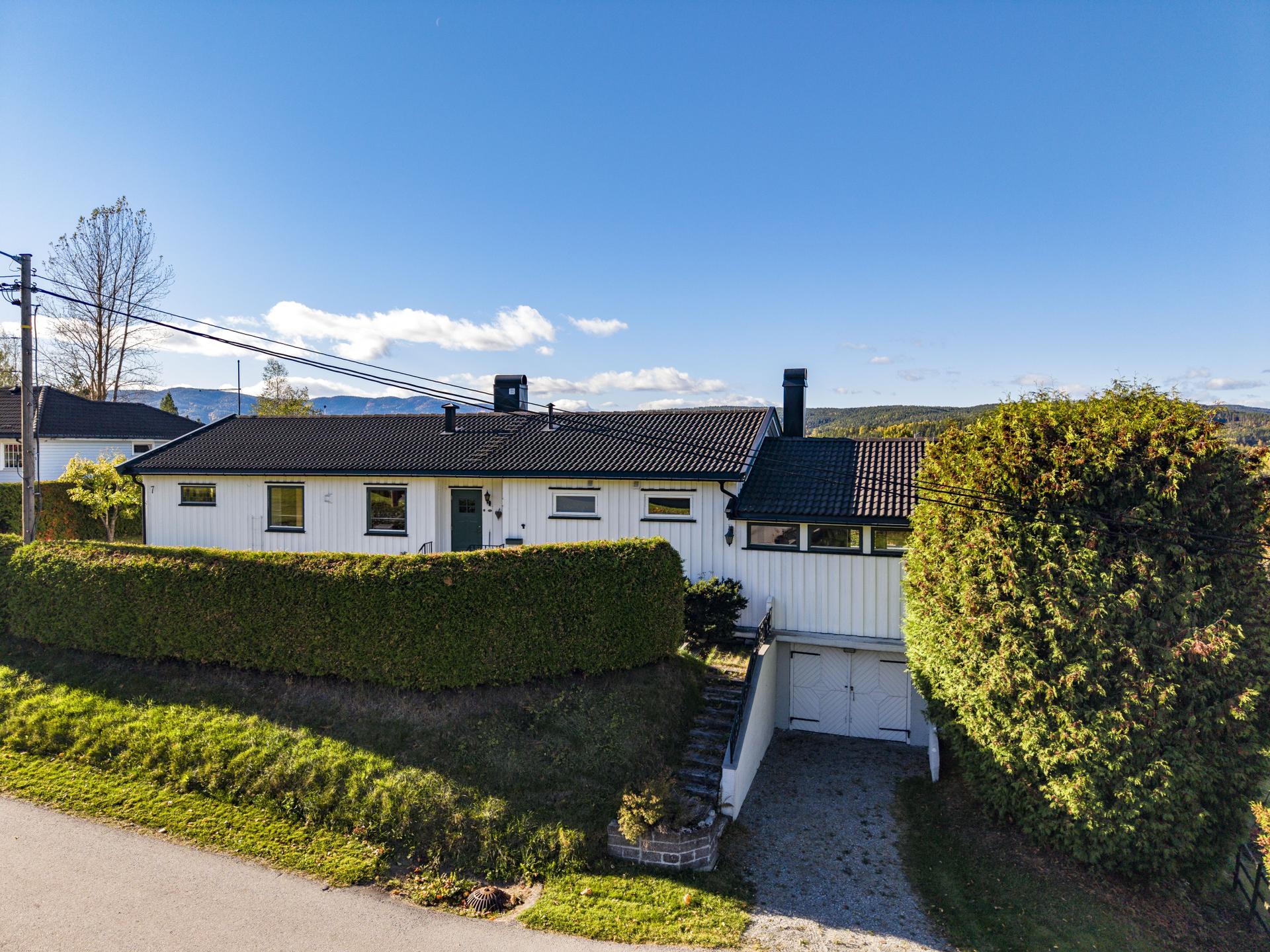 Eiendommen har integrert garasjerom i kjelleren med adkomst via gruset innkjørsel.. Bilde nummer 2 av 3