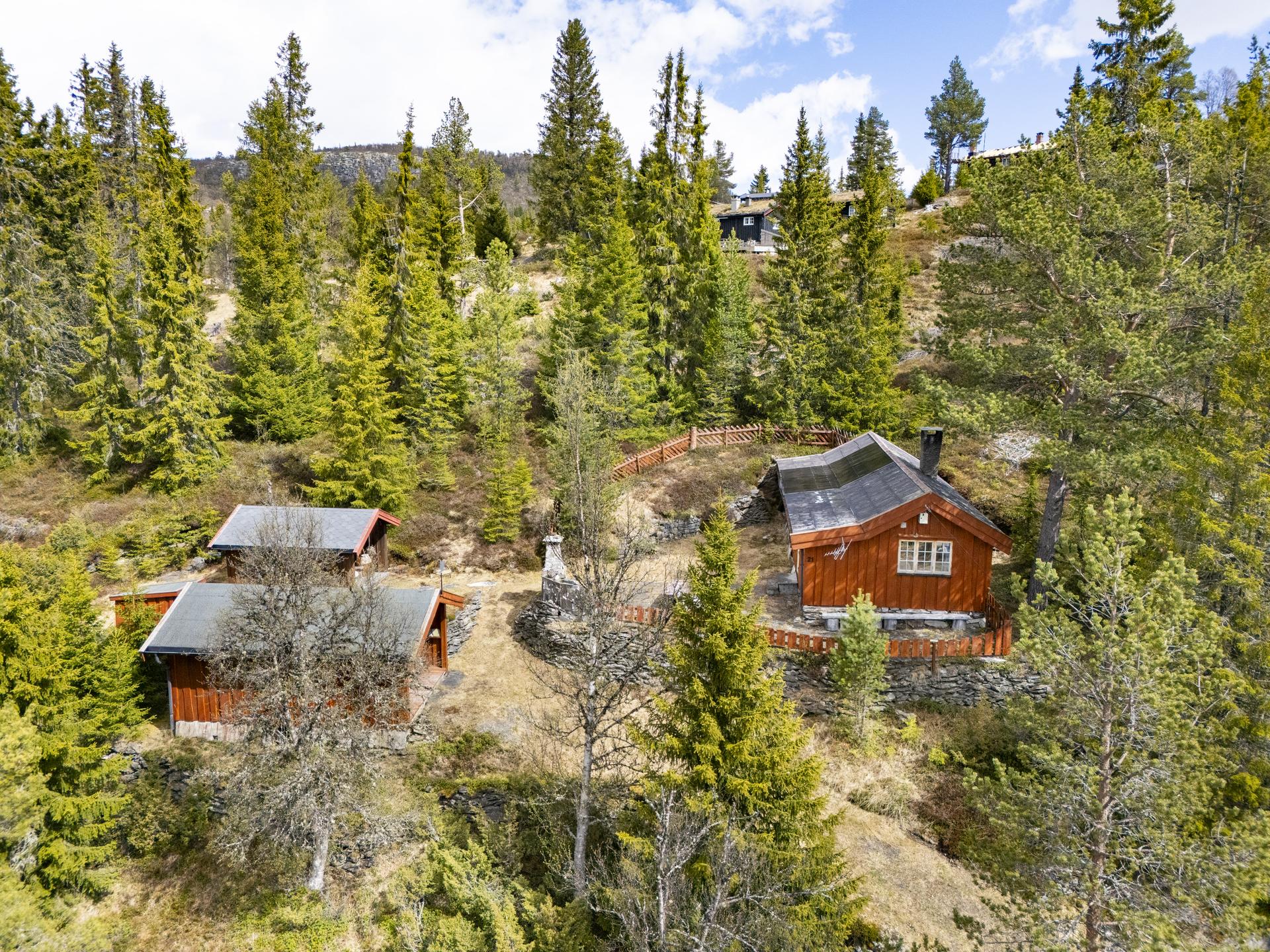 Eiendommen består av en hovedhytte, anneks, uthus og utedo, idyllisk plassert i skrånende terreng.. Bilde nummer 2 av 3