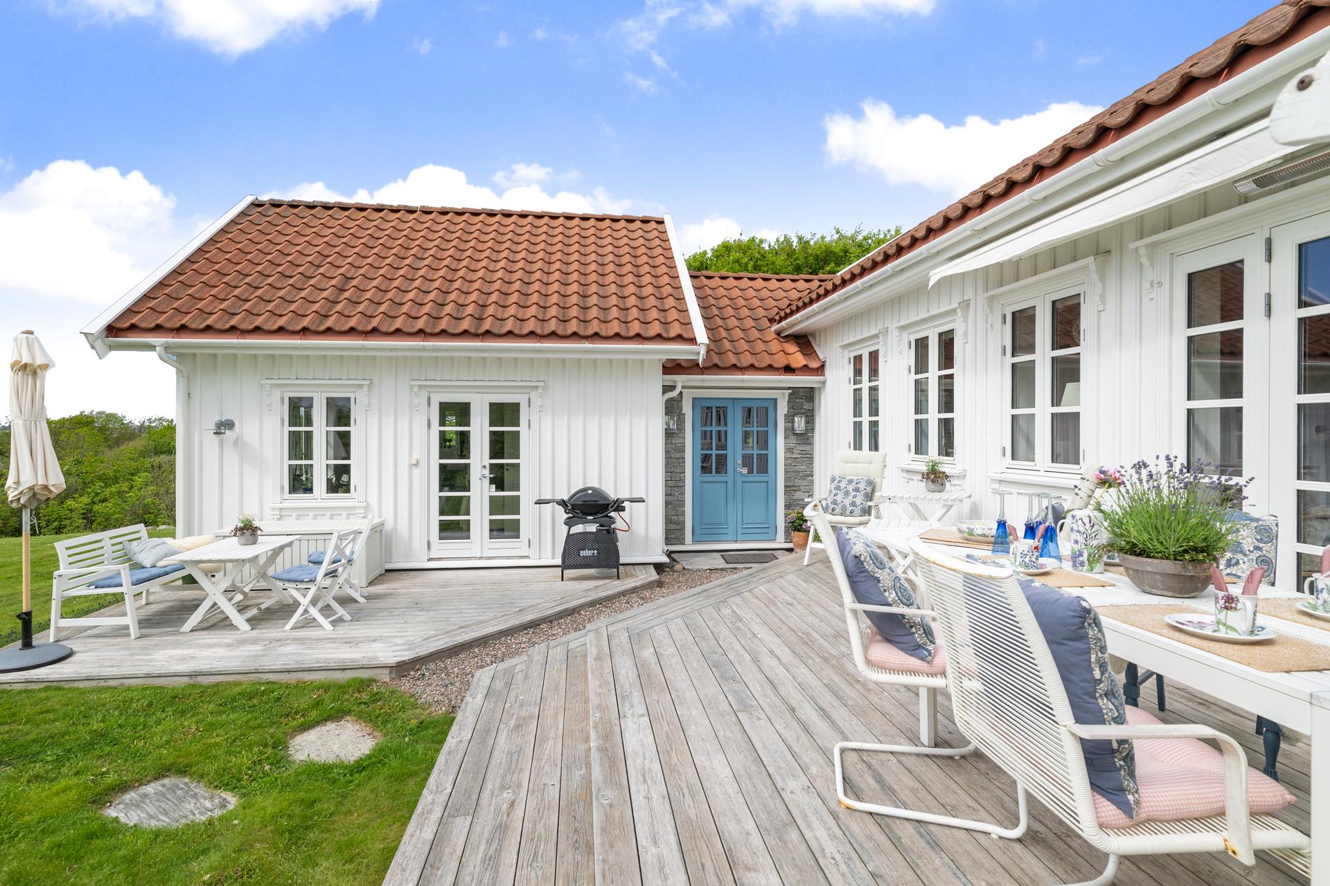 Uteplassen strekker seg rundt store deler av hytta og byr på flere soner for avslapning og måltider.. Bilde nummer 2 av 3