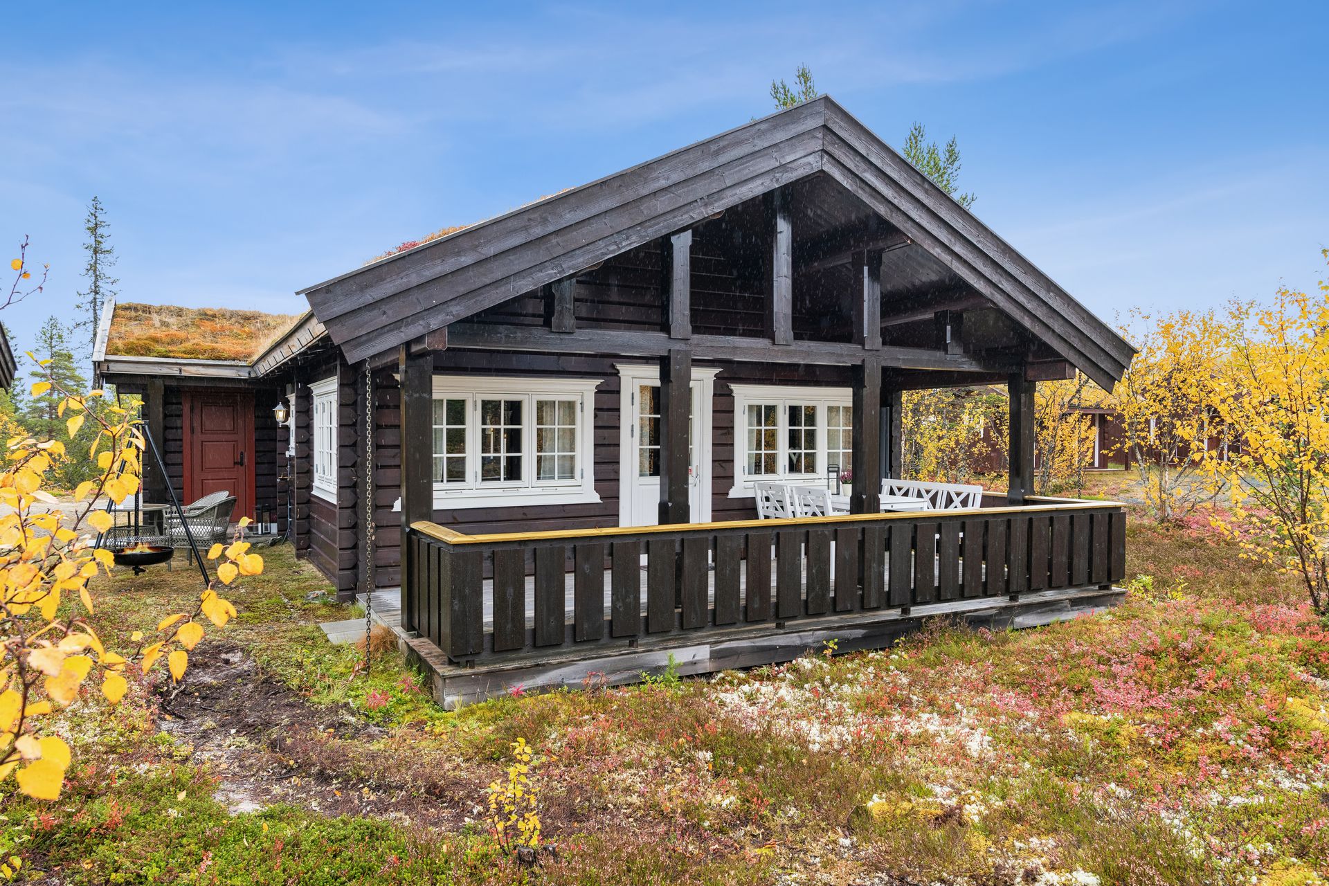 Fritidsbolig i maskinlaftet tømmer med torvtak og overbygd terrasse mot vest.. Bilde nummer 2 av 3
