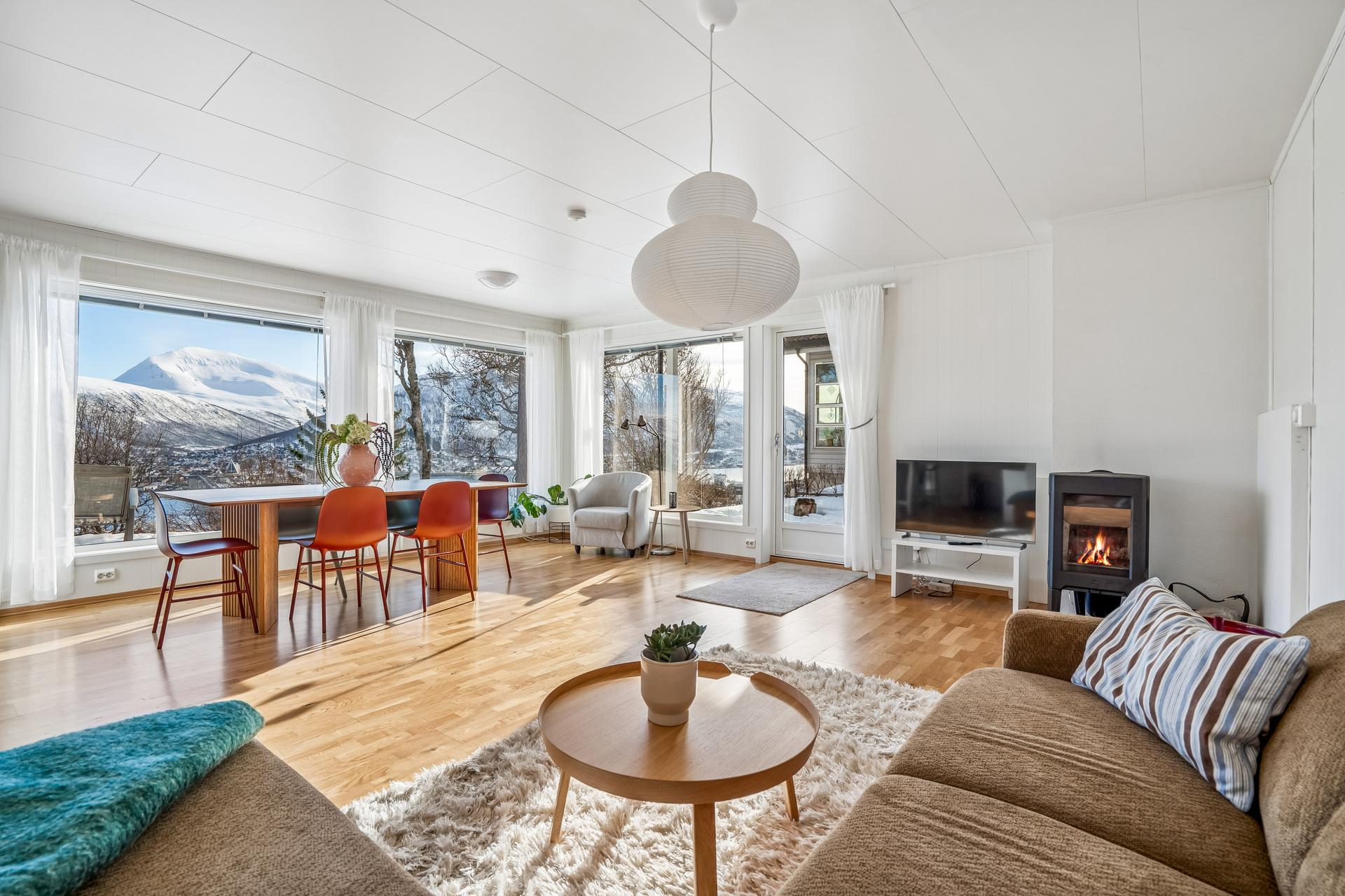 Romslig stue med store vinduer i front. . Bilde nummer 2 av 3