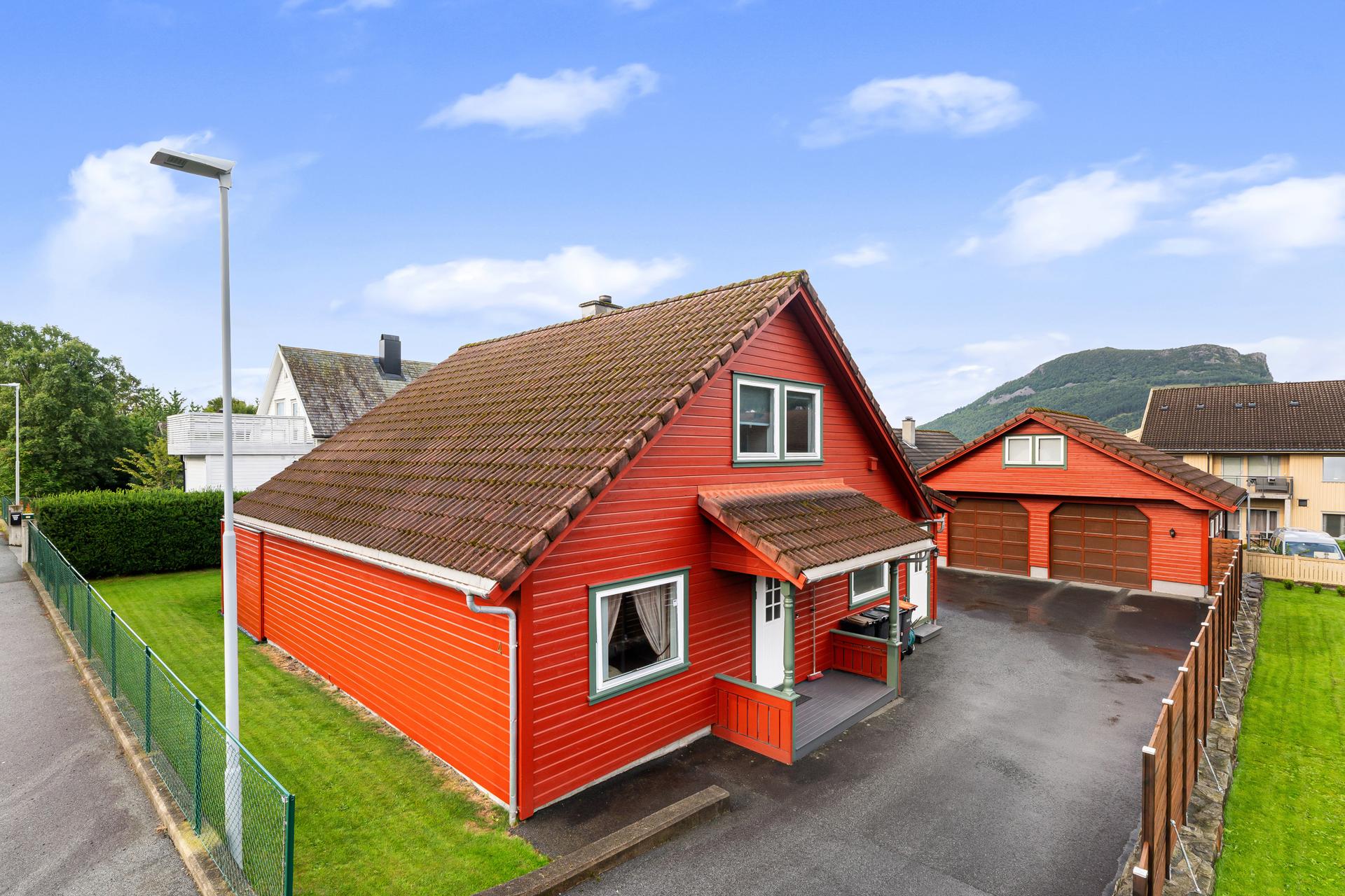 Enebolig med tilhørende garasje og uthus på en pent opparbeidet tomt.. Bilde nummer 2 av 3