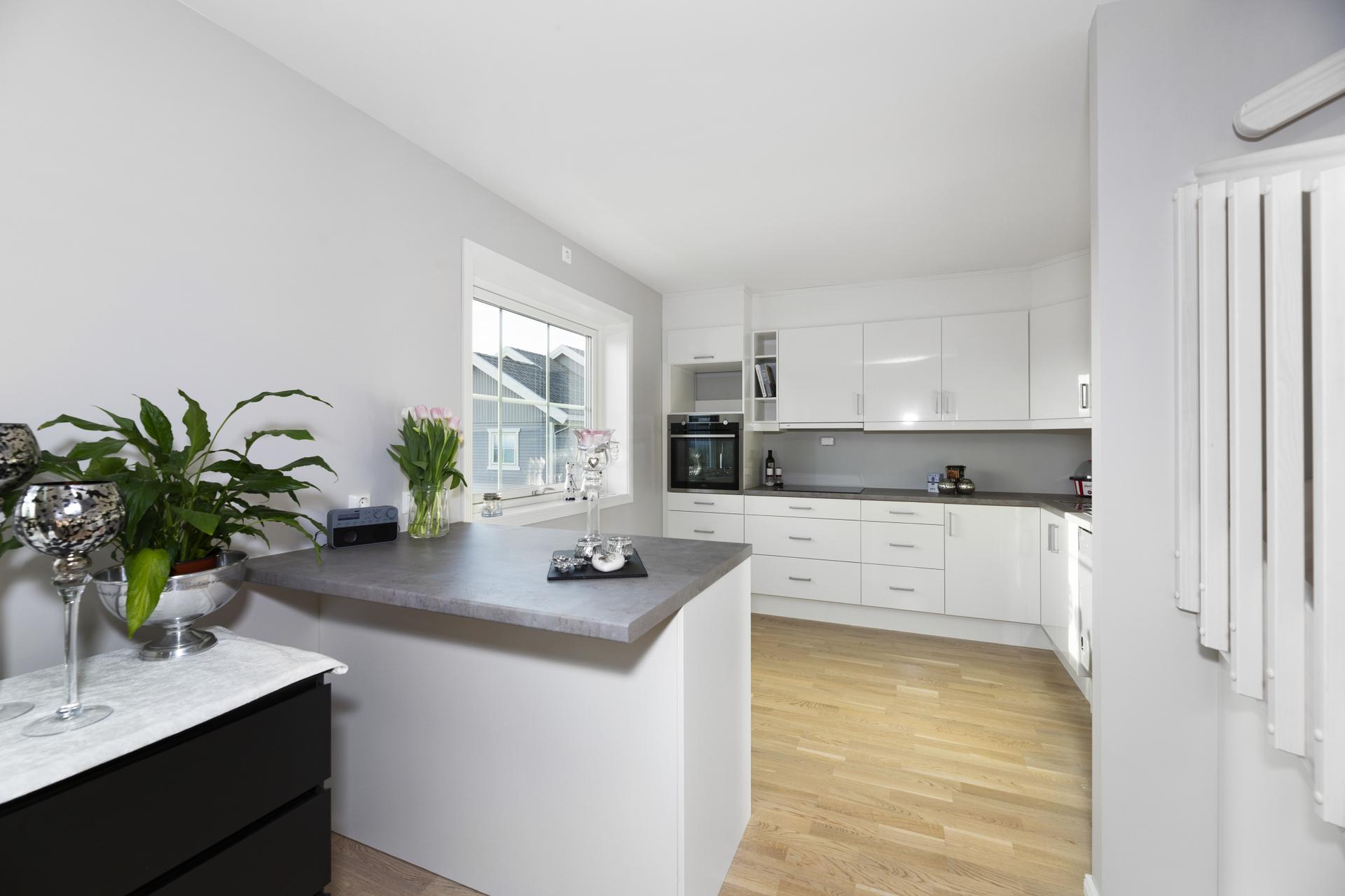 Det er en kjøkkenøy med mulighet for en spiseplass og barkrakker. Åpen løsning til spisestue/stue. Foto: Morten Normann. Bilde nummer 1 av 3