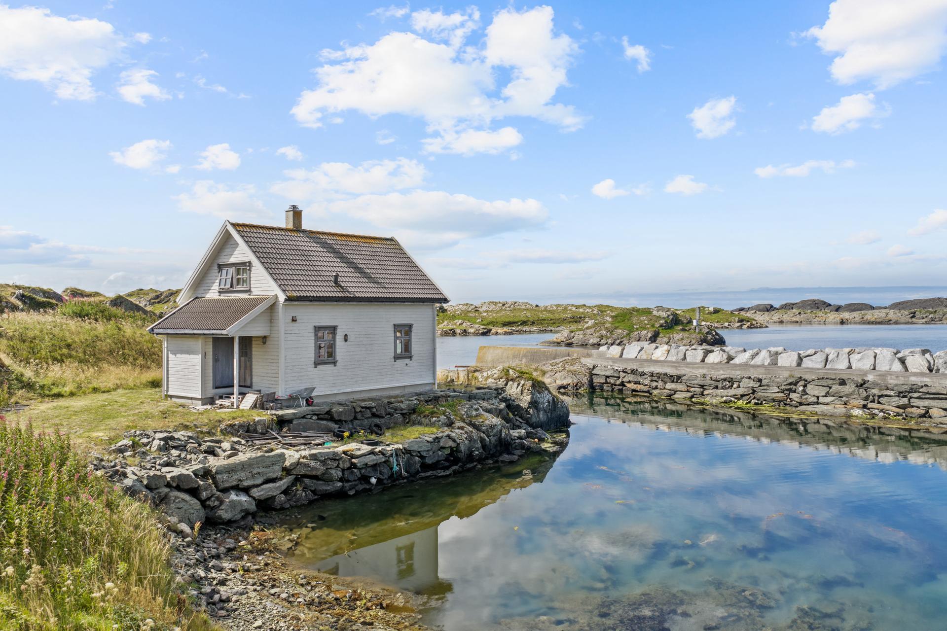 Sjøeiendom med hytte fra 2003, lagune og opparbeidet steinbrygge.. Bilde nummer 1 av 3