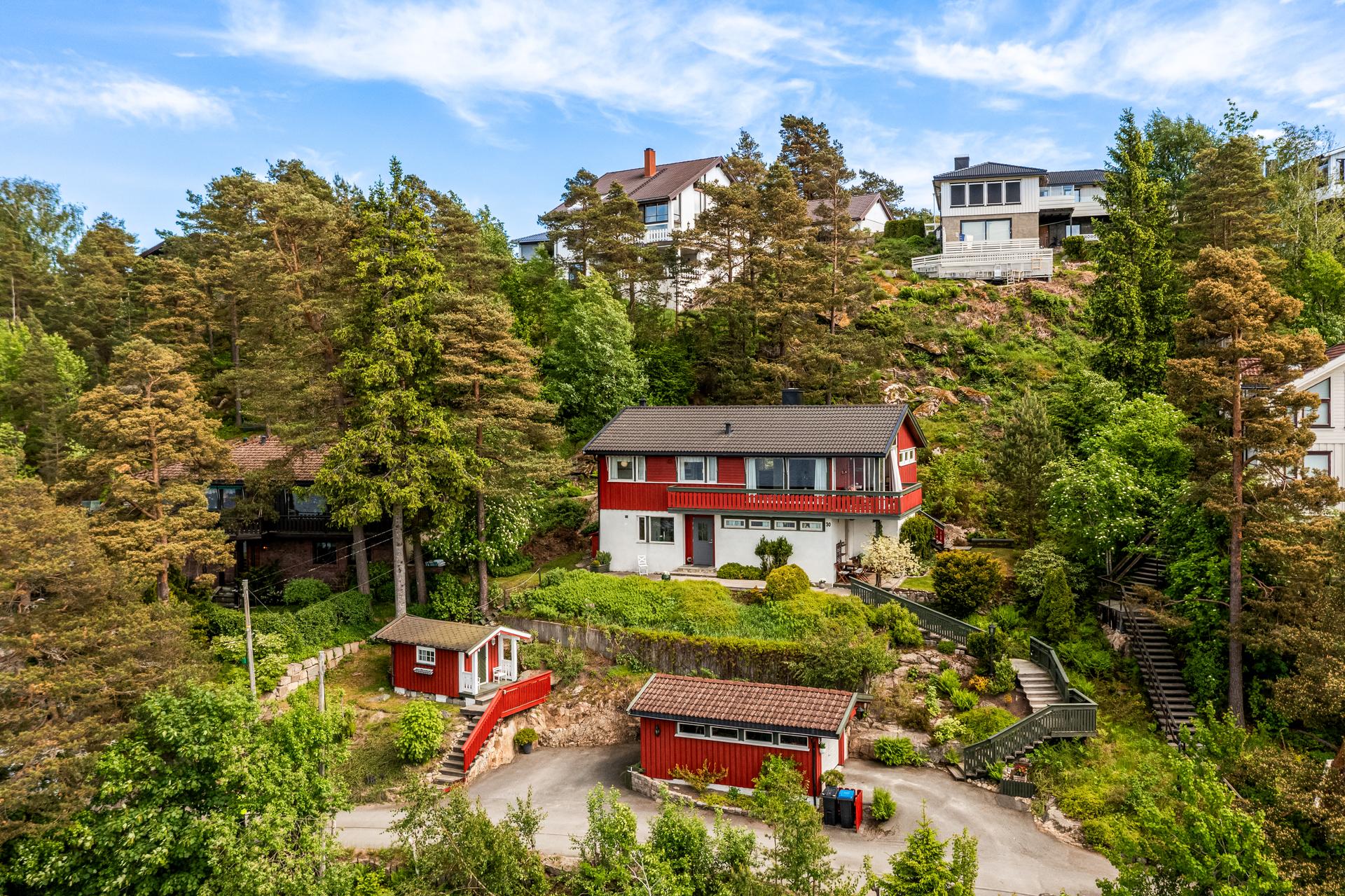 Eiendommen ligger på en skrående tomt og består av enebolig, frittstående garasje og et anneks. Adkomst til boligen via trapper i terrenget fra gårdsplass/garasje. . Bilde nummer 2 av 3