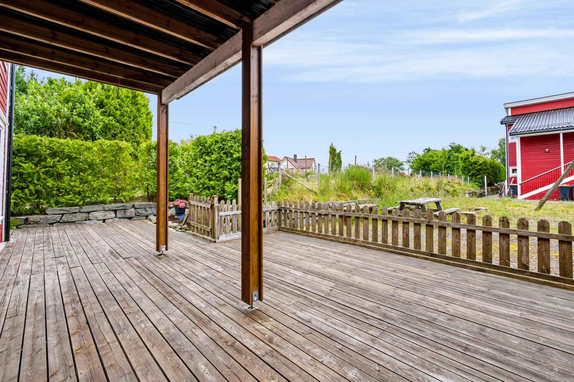 Stor og inngjerdet terrasse med god plass til utemøbler og sittegrupper.. Bilde nummer 3 av 3
