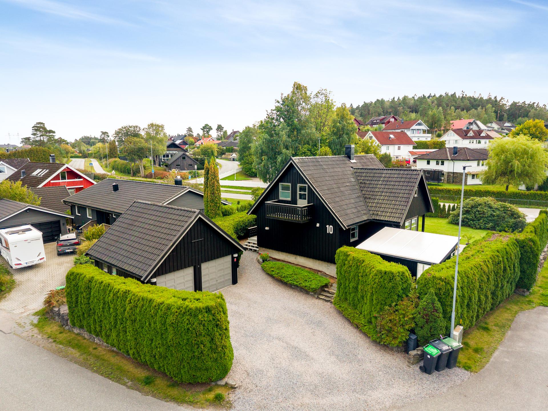 Enebolig over tre plan med stor tomt, frittstående dobbelgarasje og opparbeidede uteplasser.. Bilde nummer 2 av 3