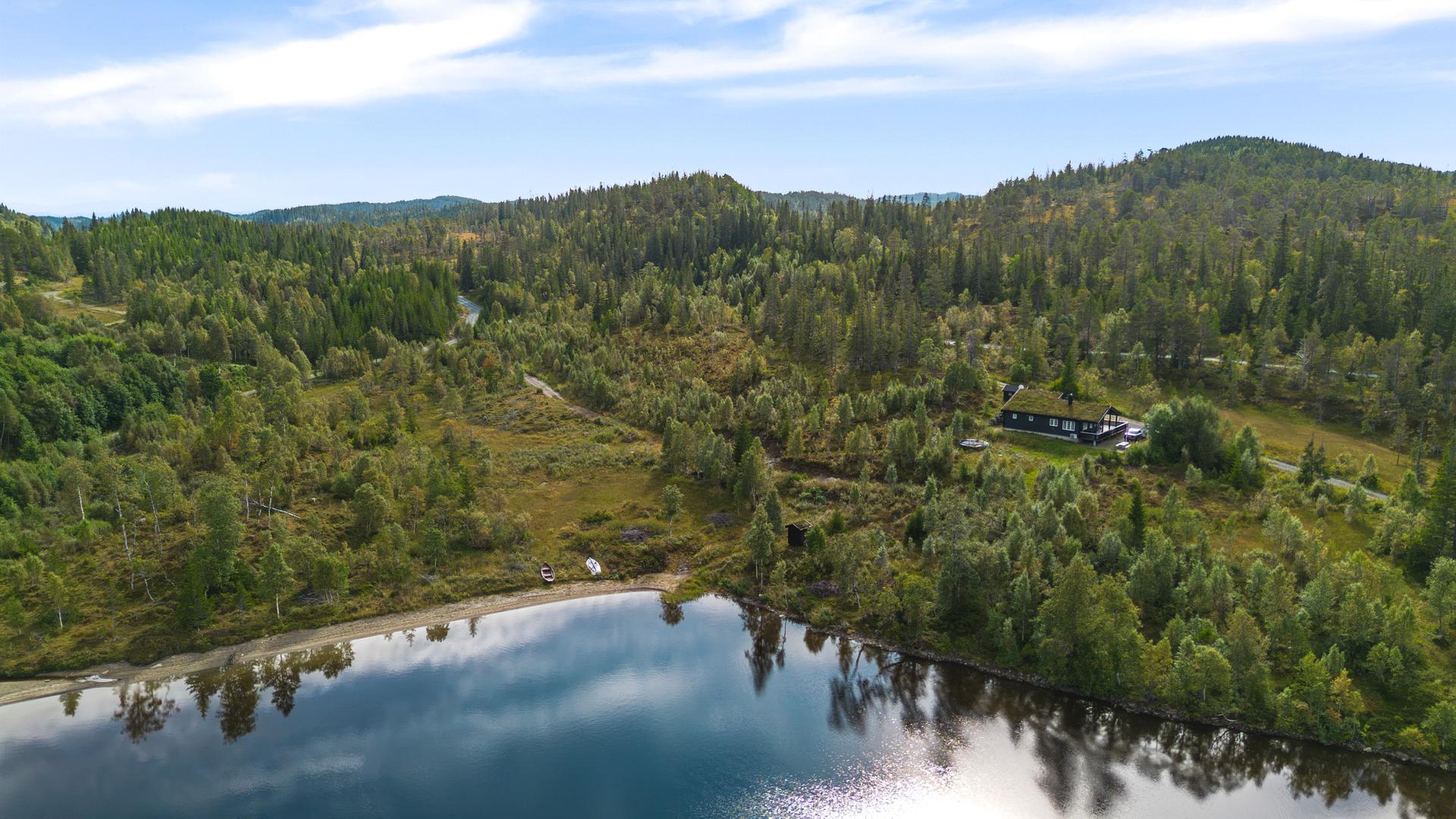 Eiendommen ligger naturskjønt til i rolige omgivelser, omgitt av skog og vakker natur.. Bilde nummer 2 av 3