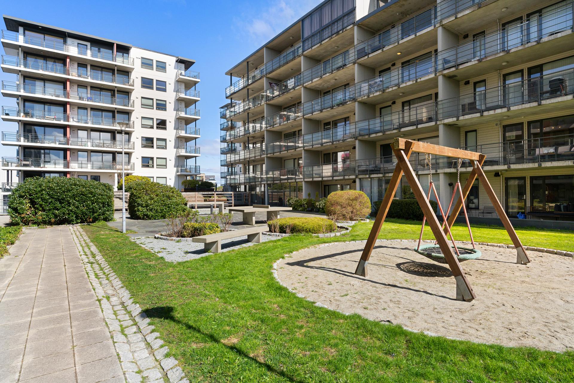 Fellesområde er opparbeidet med plen, beplantning og sitteplasser.. Bilde nummer 3 av 3