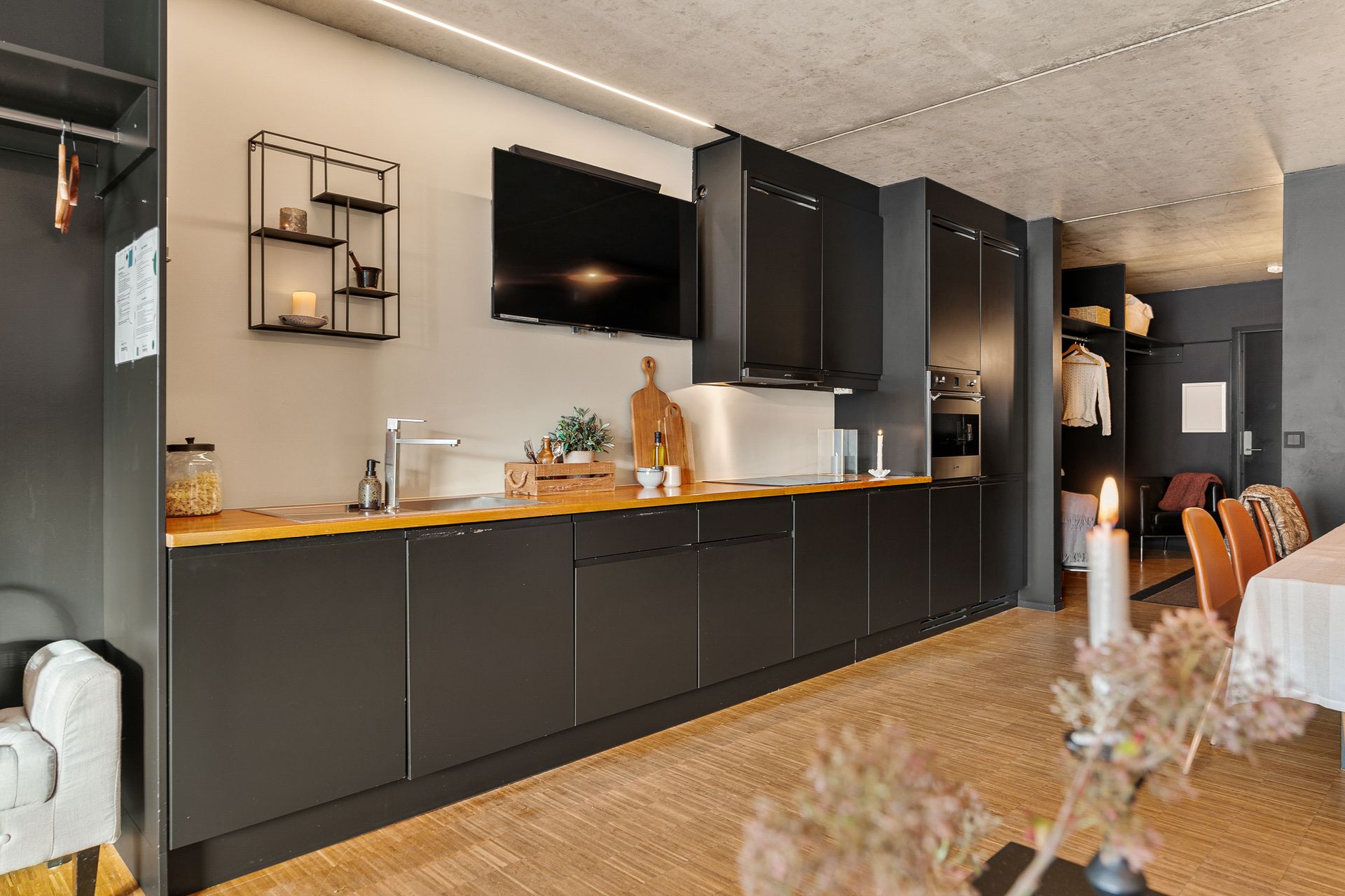 Leiligheten har en åpen stue- og kjøkkenløsning med en gjennomgående, moderne stil.. Bilde nummer 2 av 3