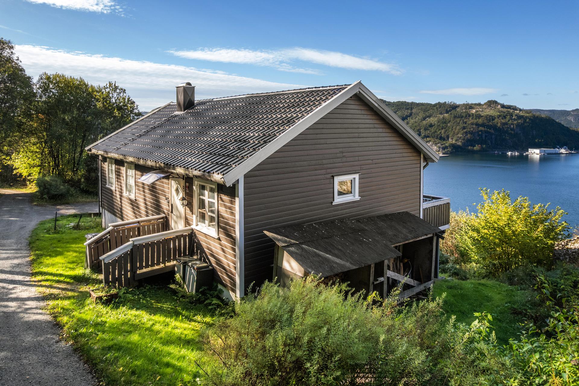 Enebolig over to plan, beliggende i skrånende terreng med utsikt mot fjorden.. Bilde nummer 2 av 3