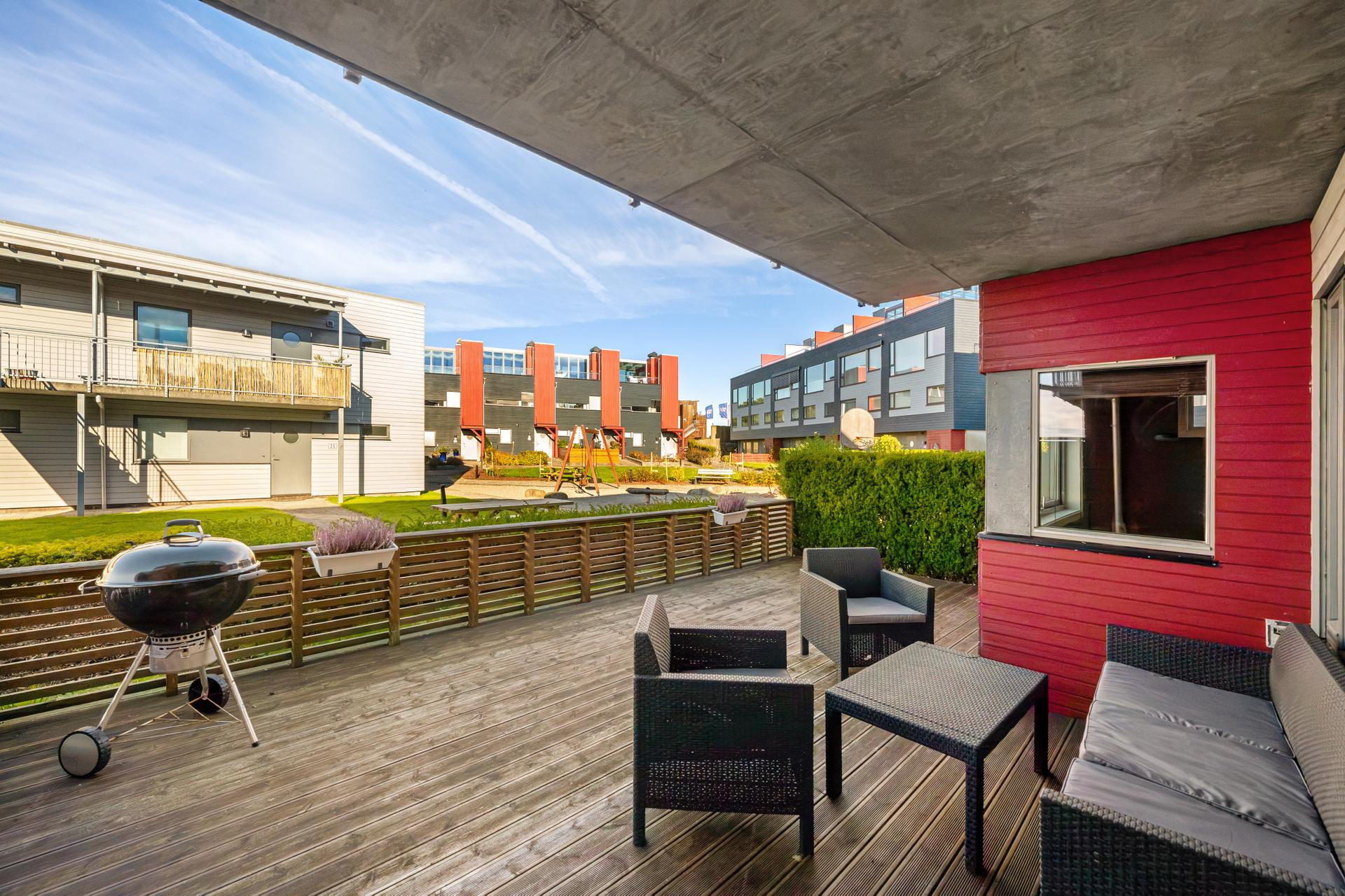 Utgang til terrasse og felles grøntareal fra stuen. Bilde nummer 2 av 3