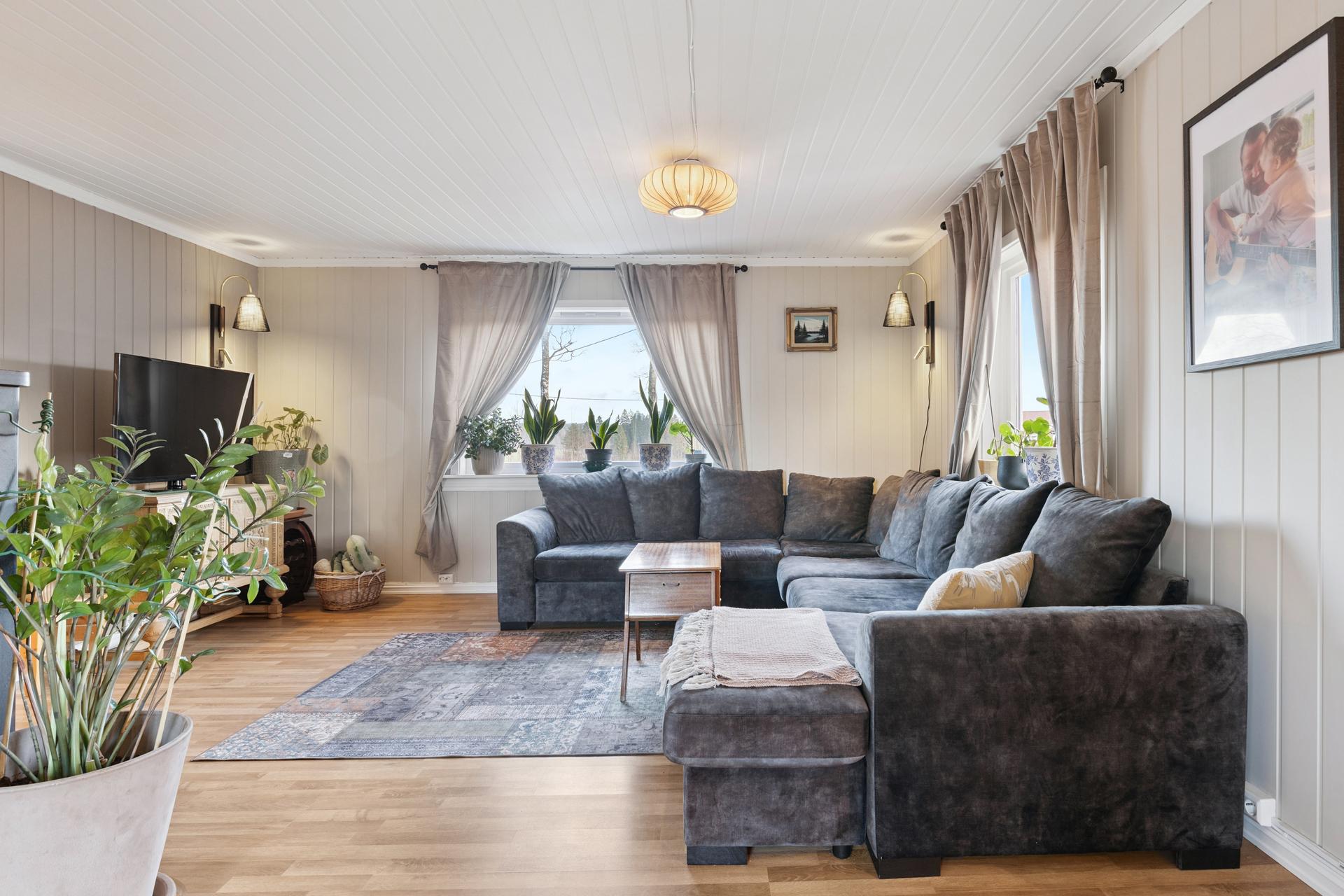 Stuen er et sosialt og romslig samlingspunkt med plass til en stor sofagruppe.. Bilde nummer 2 av 3
