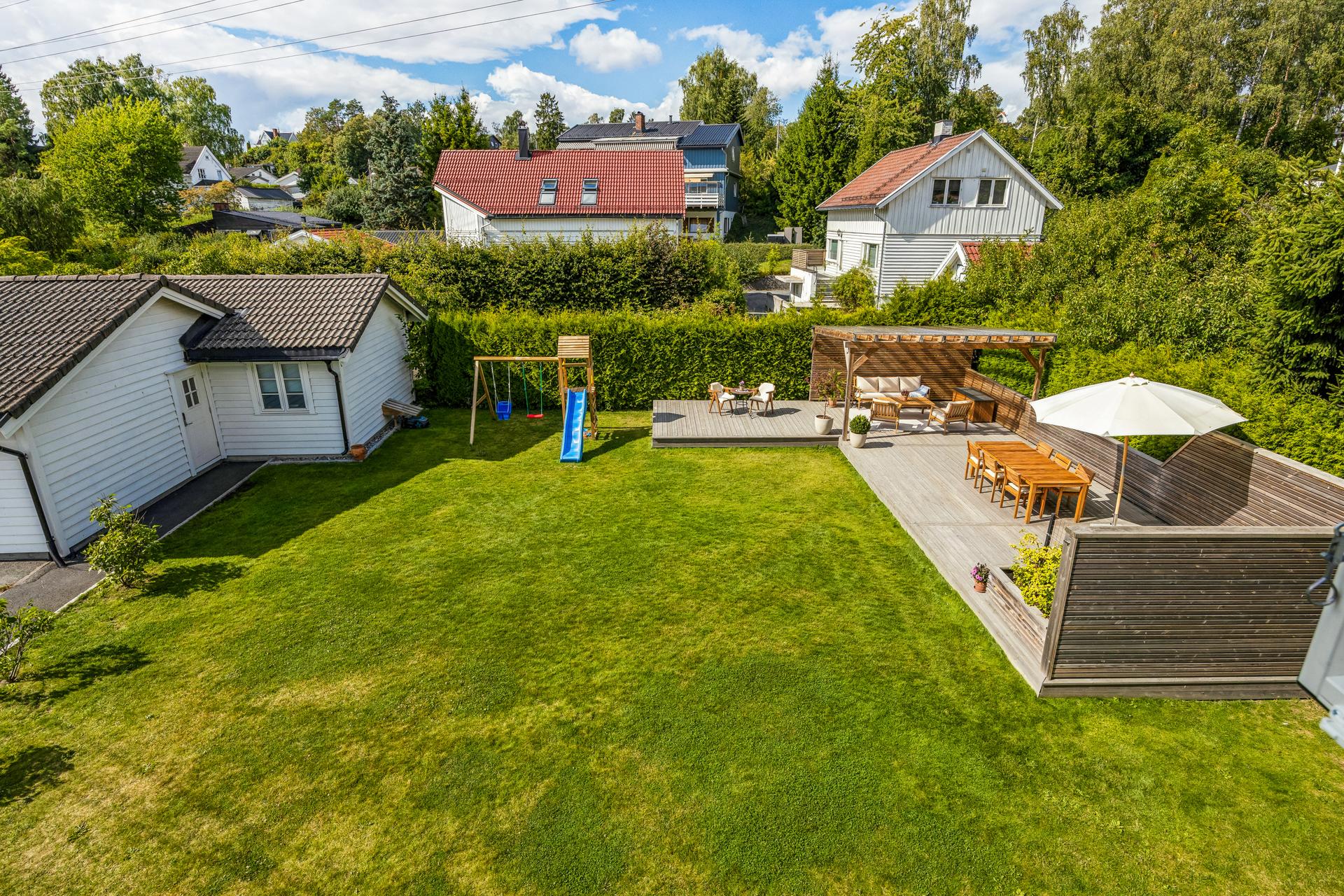 Utsyn over hagen med frittliggende markterrasse og pergola.. Bilde nummer 3 av 3