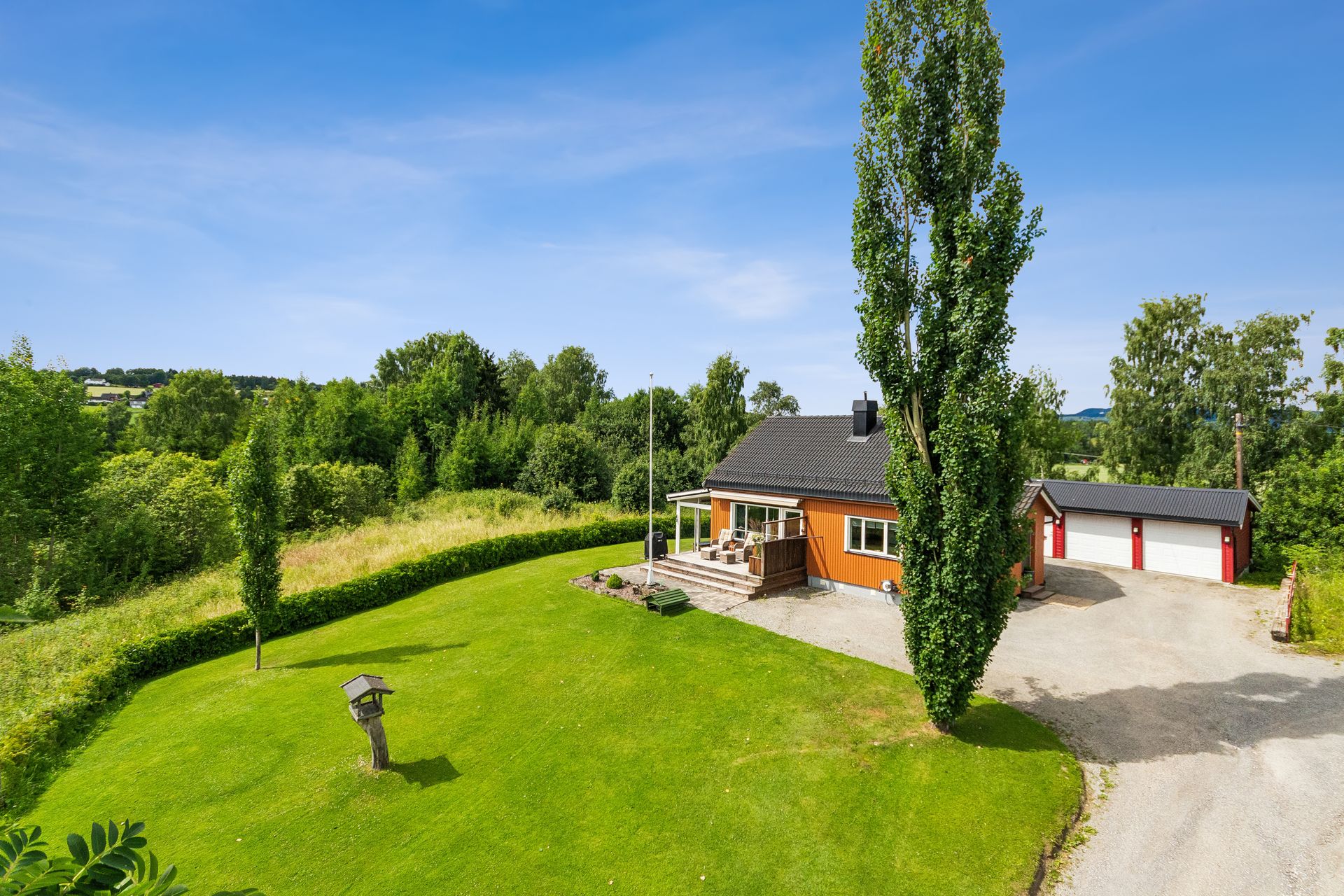 Eiendommen ligger i et svakt skrånende terreng med en stor og åpen tomt.. Bilde nummer 3 av 3