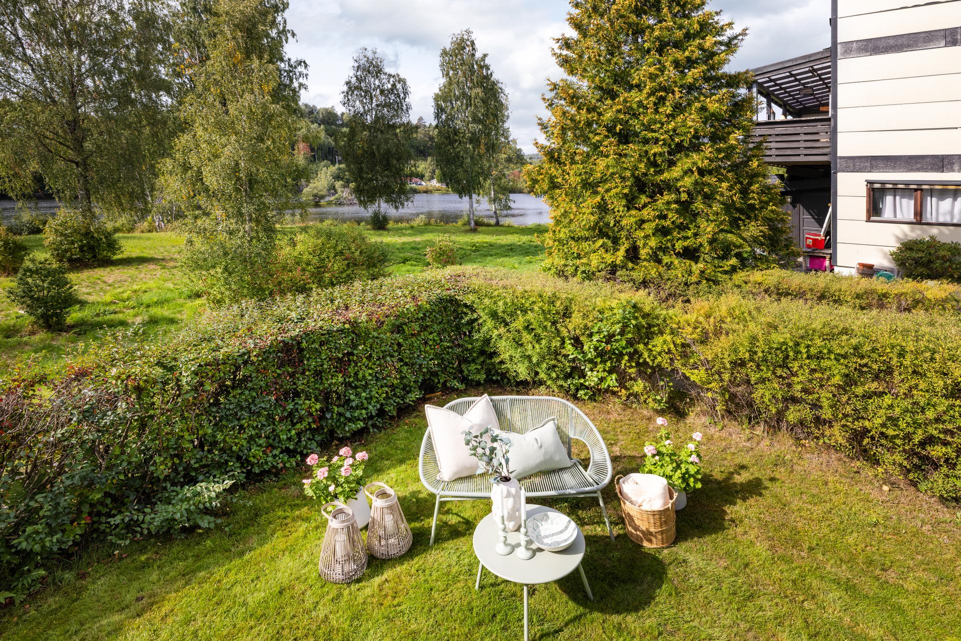 Uteplass i hagen med utsikt mot elva og omkringliggende natur.. Bilde nummer 3 av 3