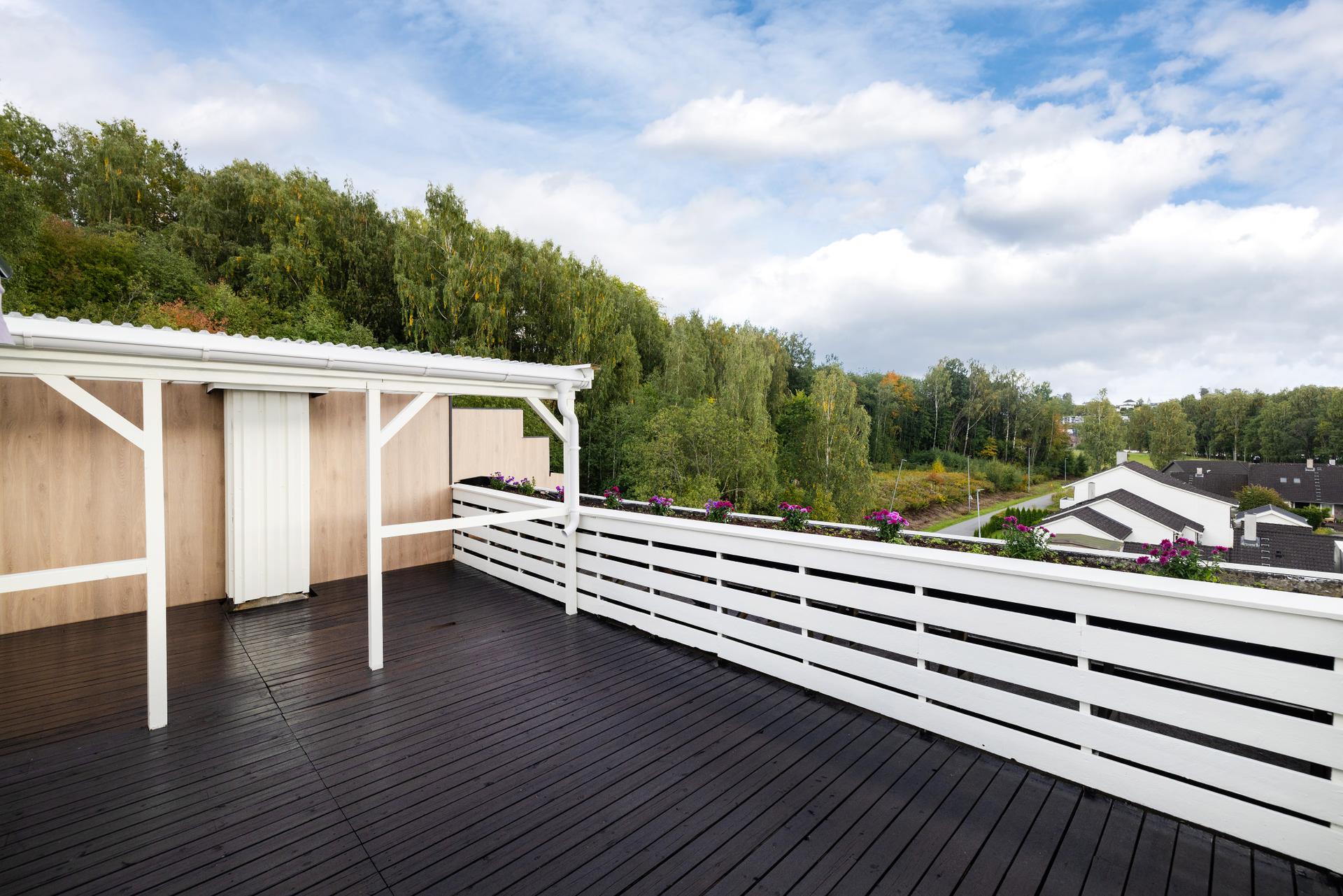 Velkommen til Hengsleveien 104! Foto: Normann Foto AS v/Morten Normann Larsen. Verandaen er omkranset av hvitmalt rekkverk og har grønt utsyn over nærområdet.. Bilde nummer 1 av 3