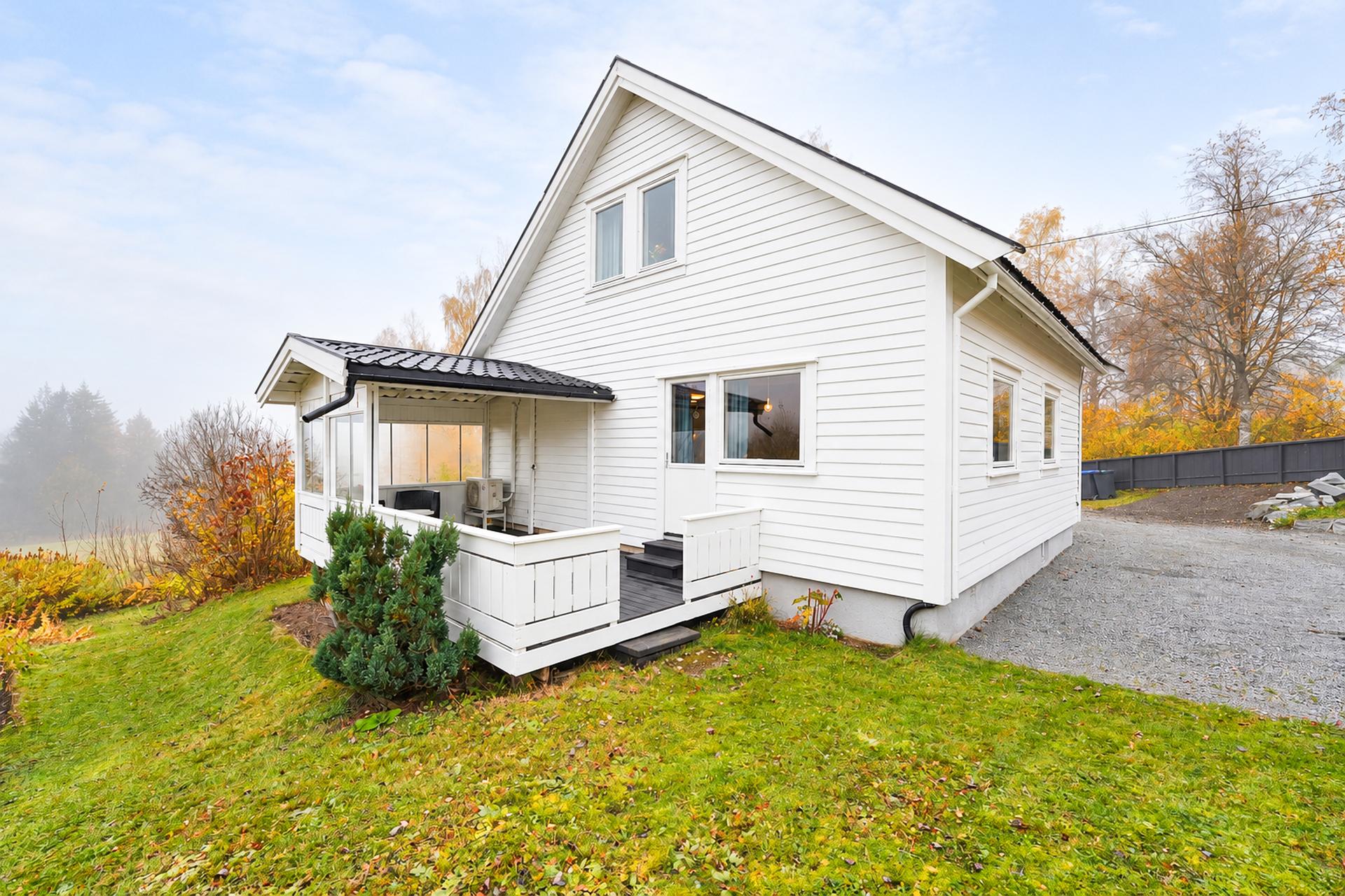 Den overbygde terrassen mot sør har adkomst fra stuen og videre tilgang til hagen.. Bilde nummer 3 av 3