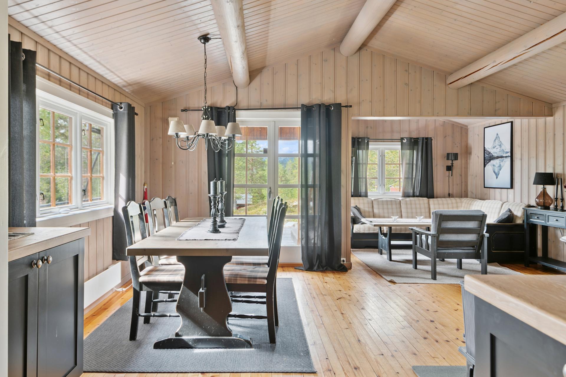 Den første av to stuer er et lunt samlingspunkt med god plass til både spise- og sofagruppe.. Bilde nummer 3 av 3