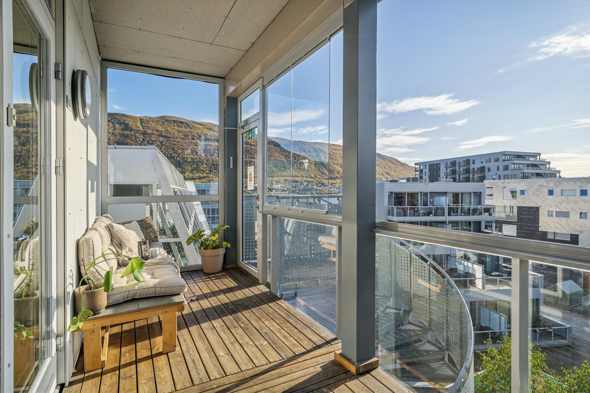 Innglasset balkong med utsyn mot sundet og fjellandskapet.. Bilde nummer 3 av 3