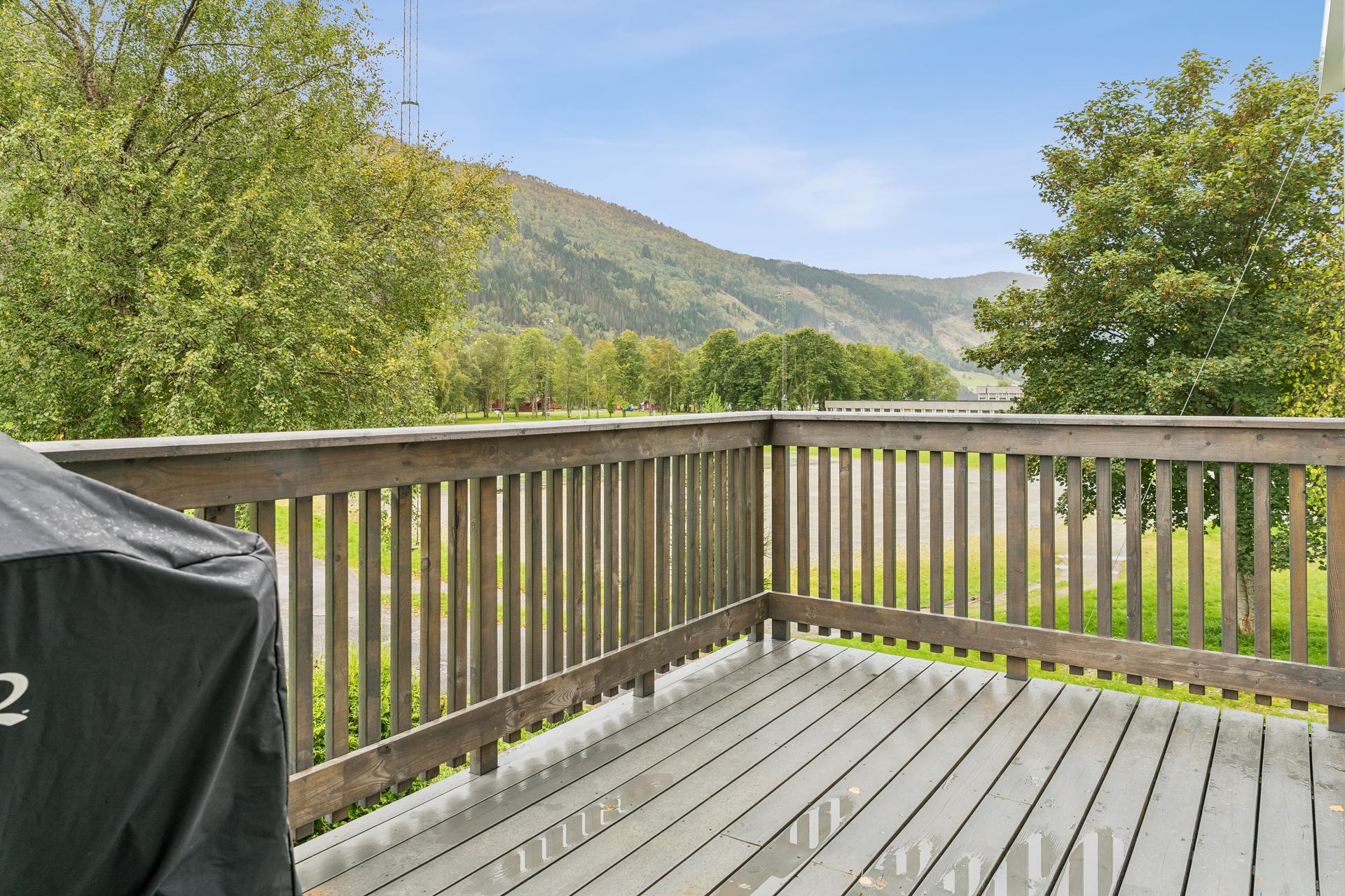 Frå stova er det direkte utgang til ein sørvendt balkong med måla terrassebord og flott utsyn over nærområdet.. Bilde nummer 3 av 3