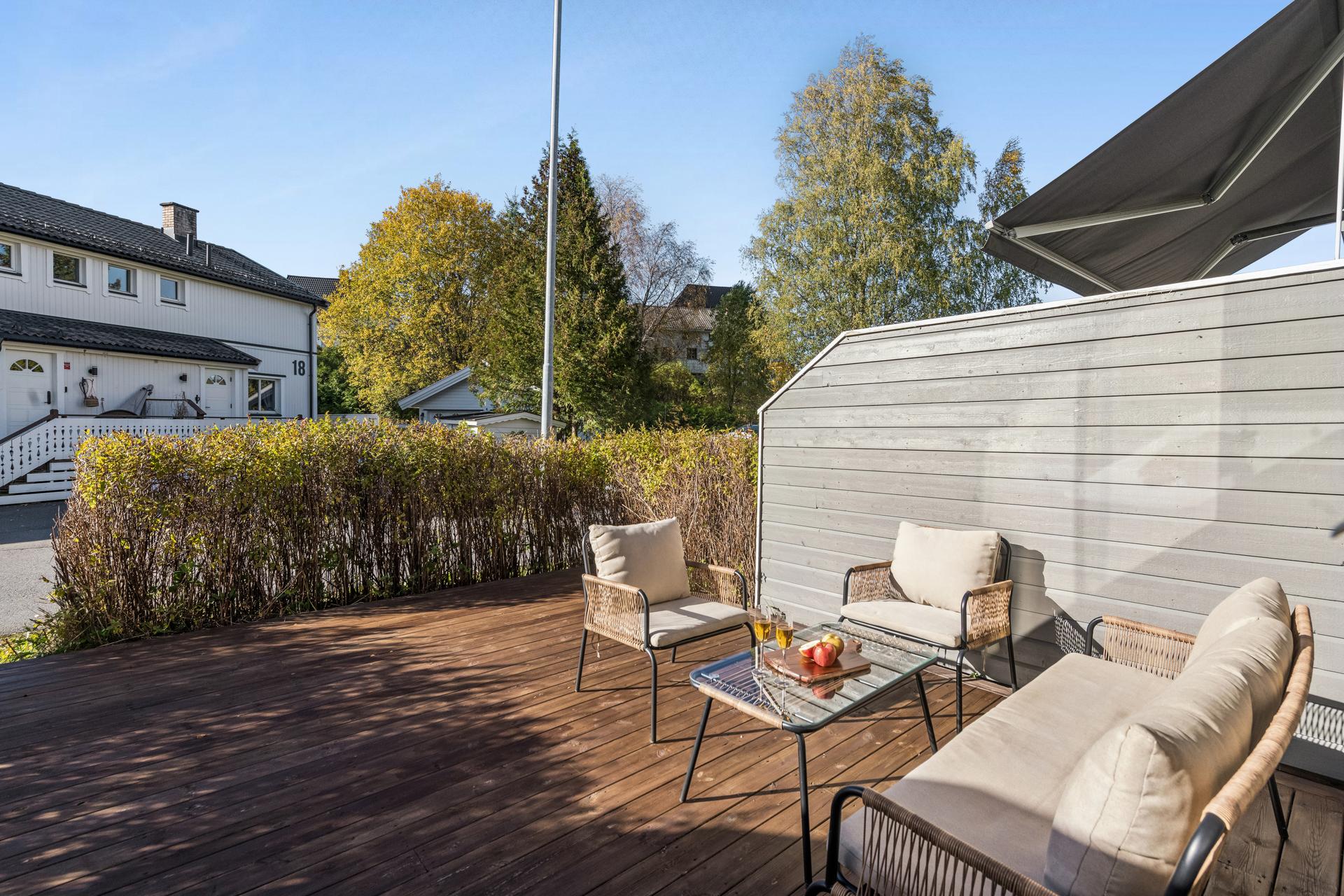 Vestvendt treterrasse med god plass til sittegruppe, skjermet med hekk og skjermvegger.. Bilde nummer 2 av 3