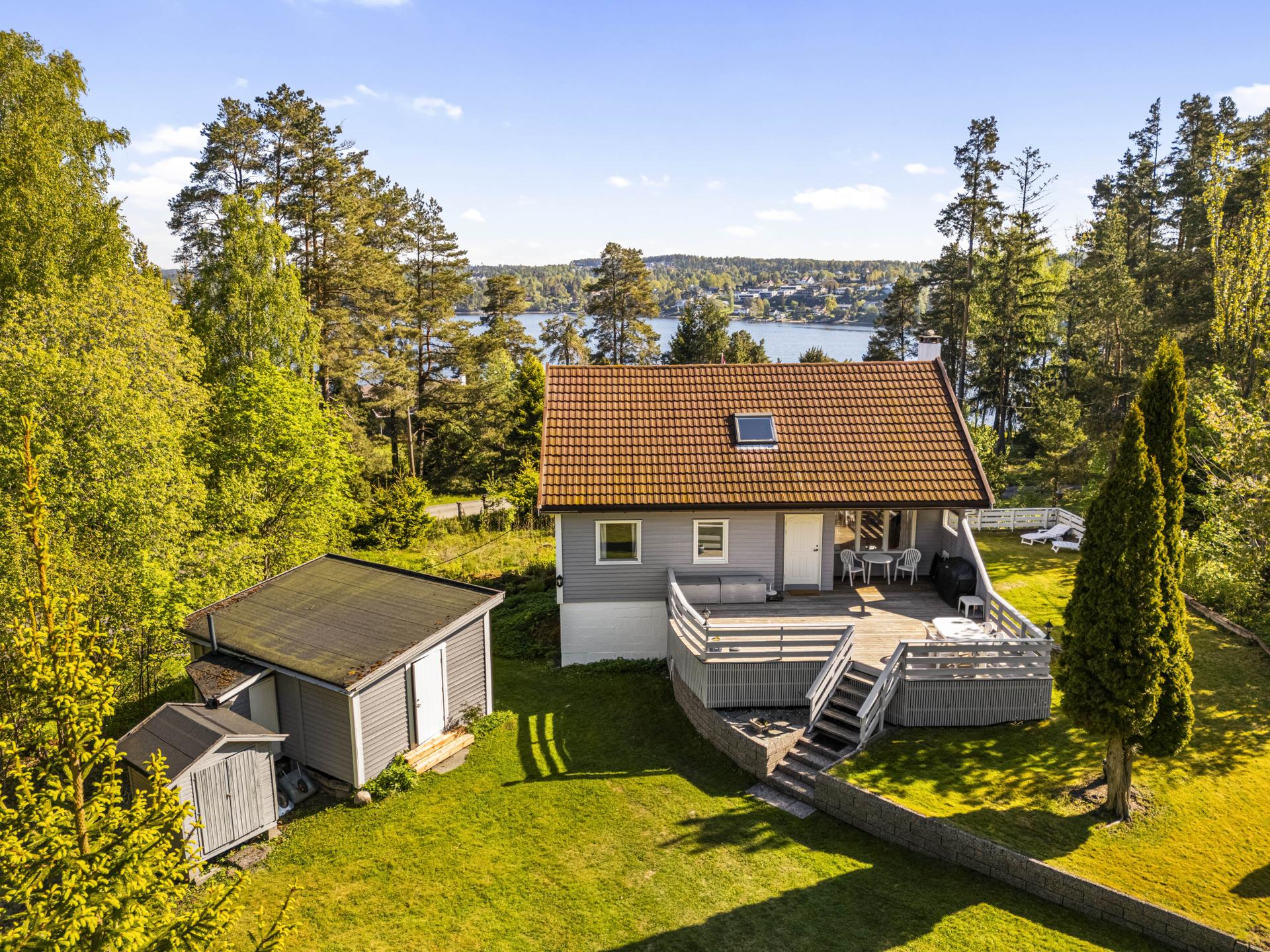 Boligen og annekset sett fra luften, med sjøen i bakgrunnen.. Bilde nummer 2 av 3