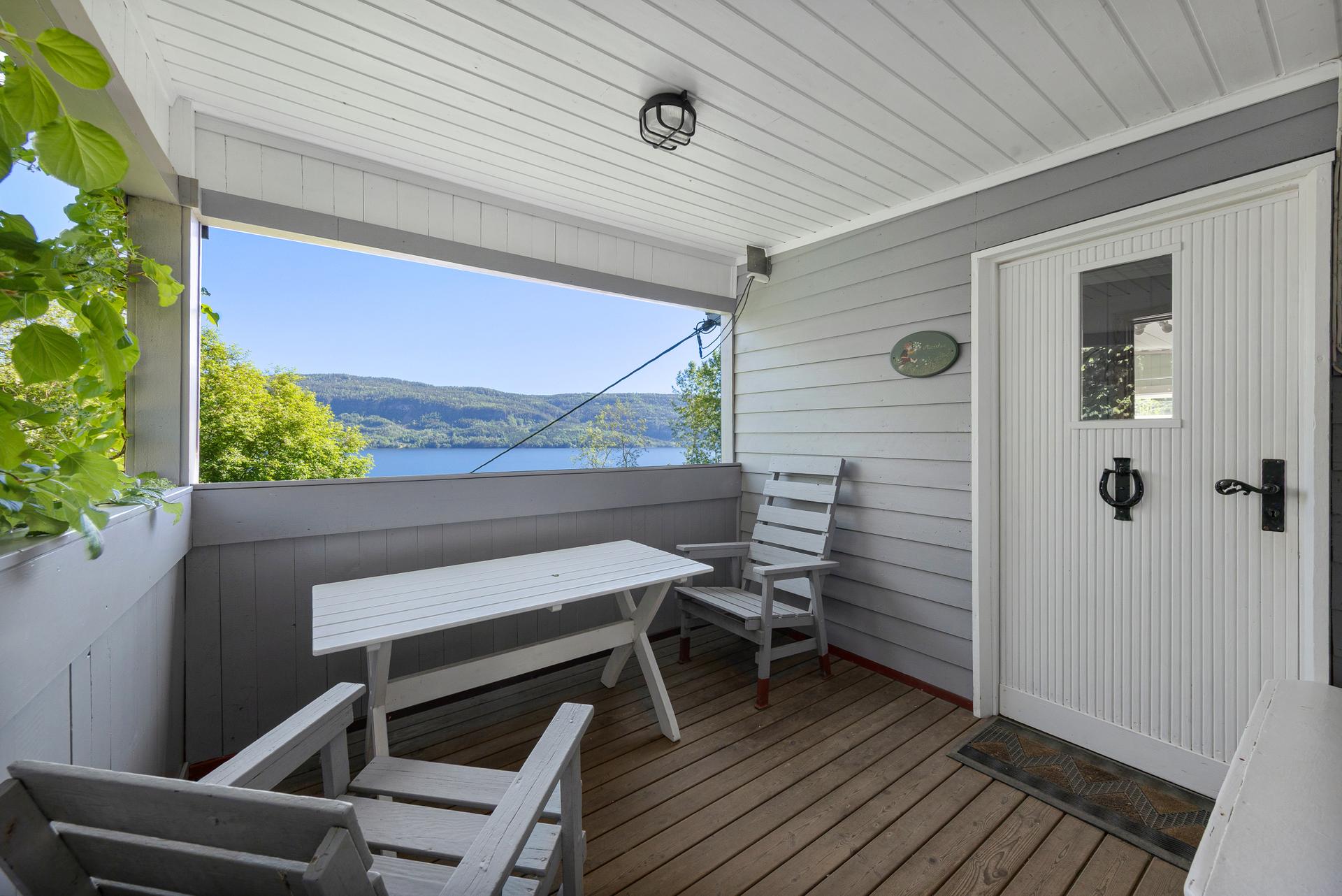 Fra den overbygde terrassen er det utsikt over Holsfjorden. Eiendommen ligger i et bratt, skrånende terreng.. Bilde nummer 3 av 3