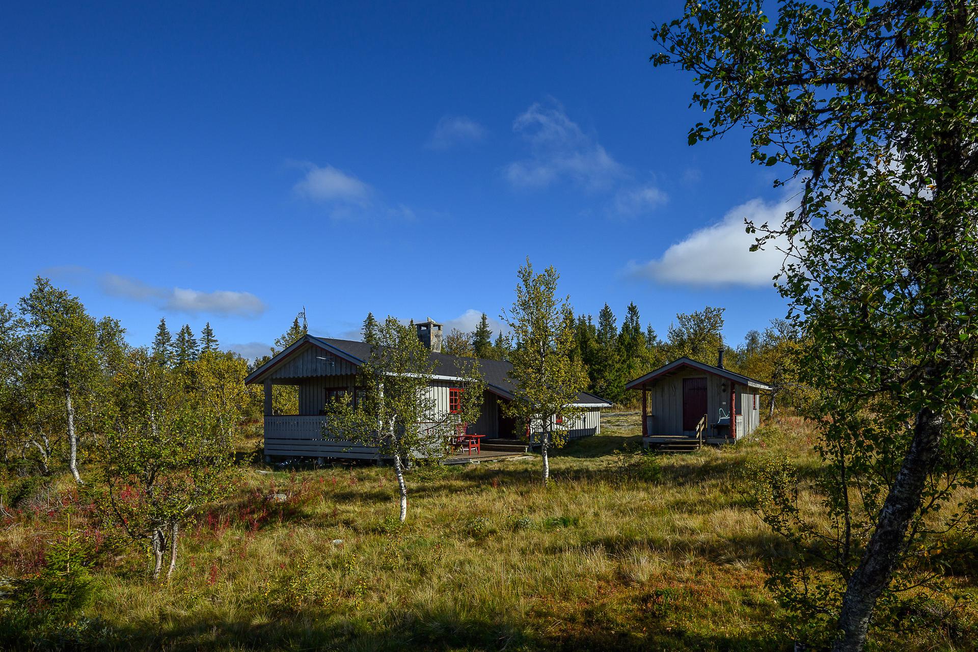 Fritidsbolig oppført i 1984 med frittstående uthus, beliggende på en usjenert naturtomt.. Bilde nummer 2 av 3